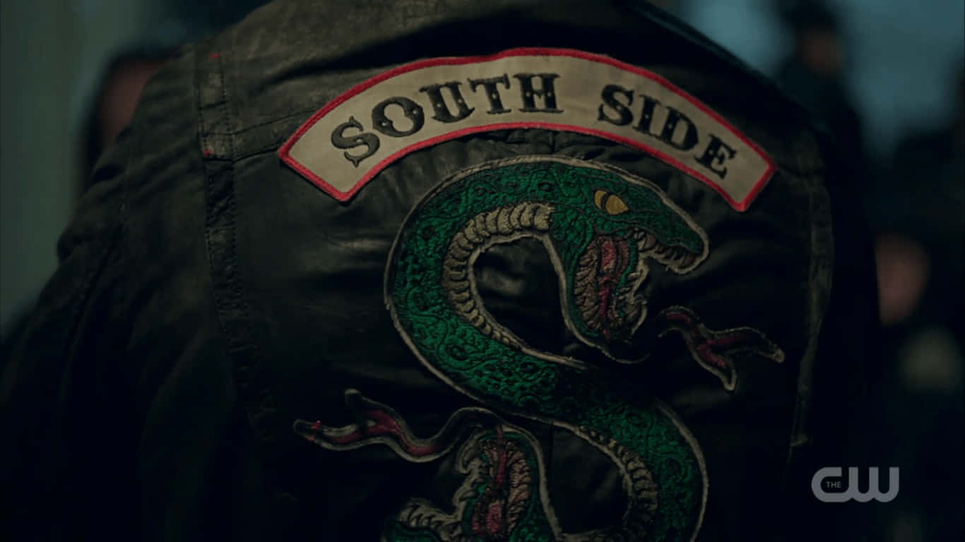 Southside Serpents 桌布 壁紙 — 暗光下深色皮背心近距離特寫，帶有綠色刺繡蛇和「SOUTH SIDE」補丁。