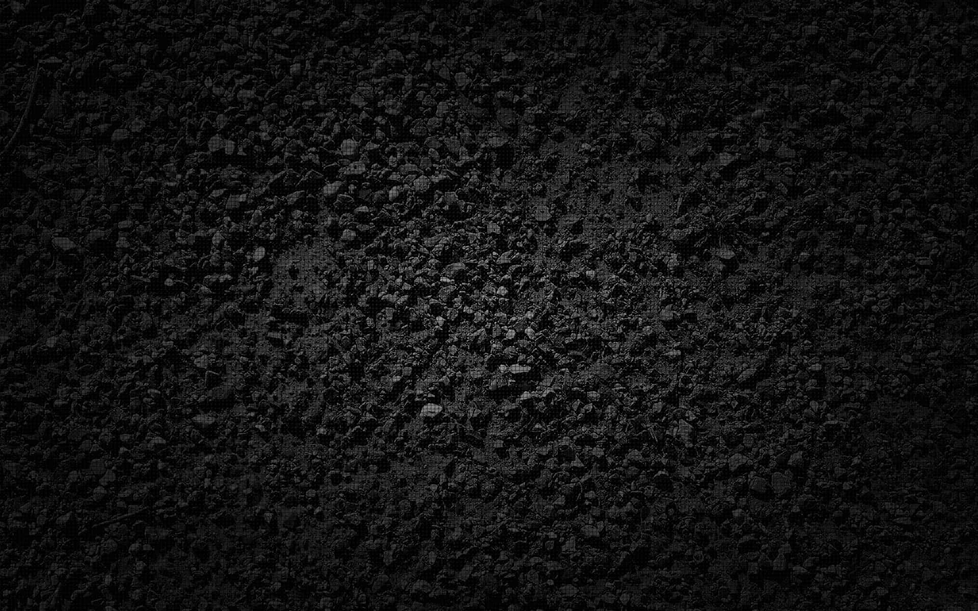 Dark Rock 桌布 壁紙 — 暗光下粗糙深色礫石紋理的近距離拍攝，帶有微妙的色調變化。