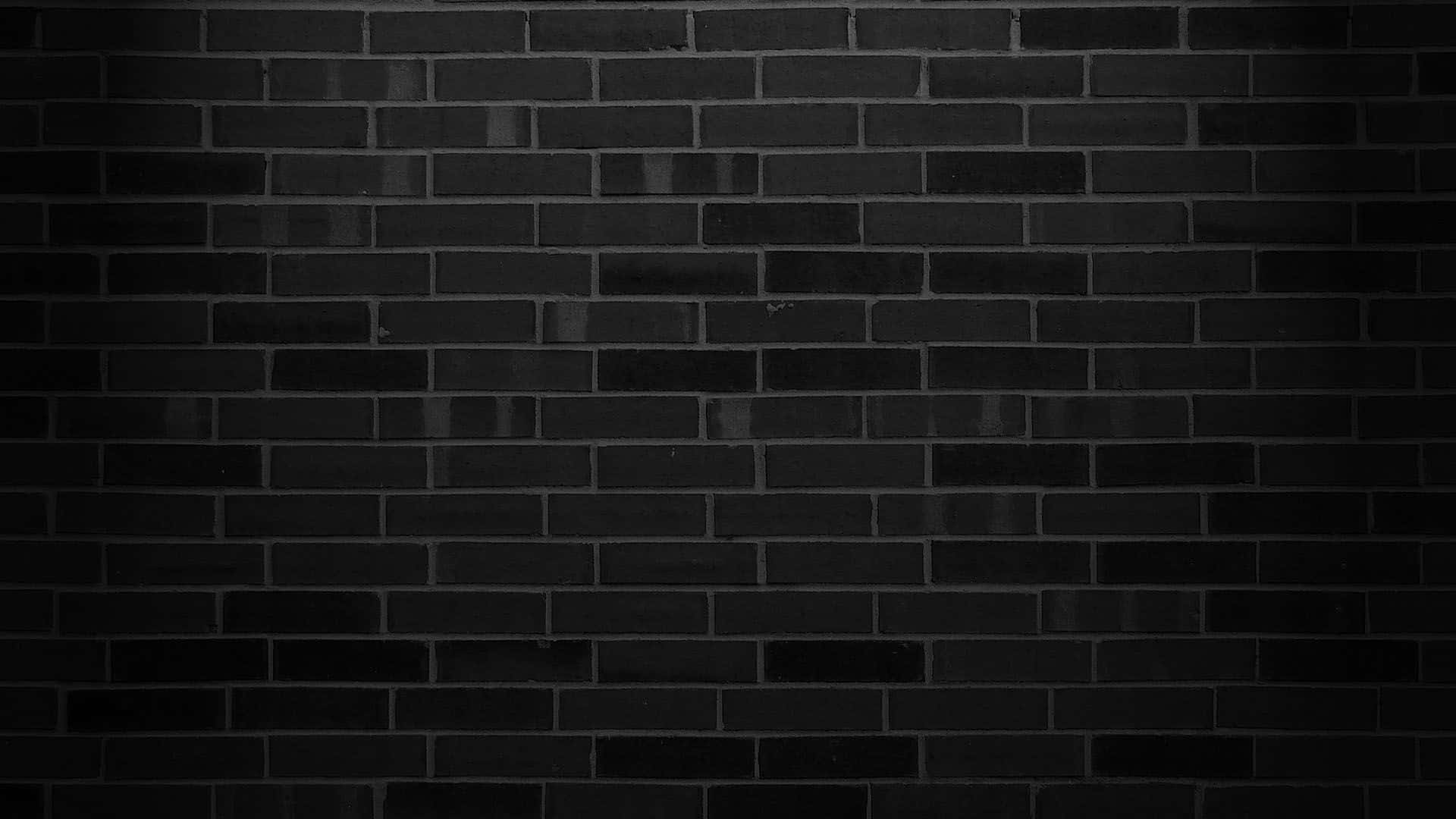 Dark Wall 桌布 壁紙 — 暗啞黑色磚牆的特寫，帶有細微紋理和微弱光線反射。