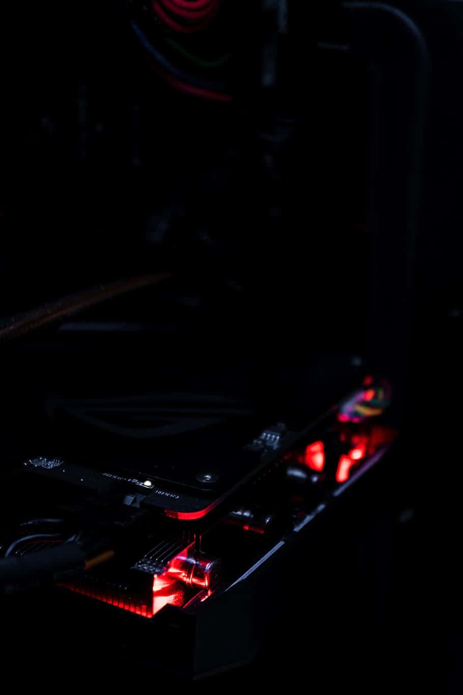 Gaming Setup 桌布 壁紙 — 暗房內電腦主機板發出紅色LED燈光的特寫。