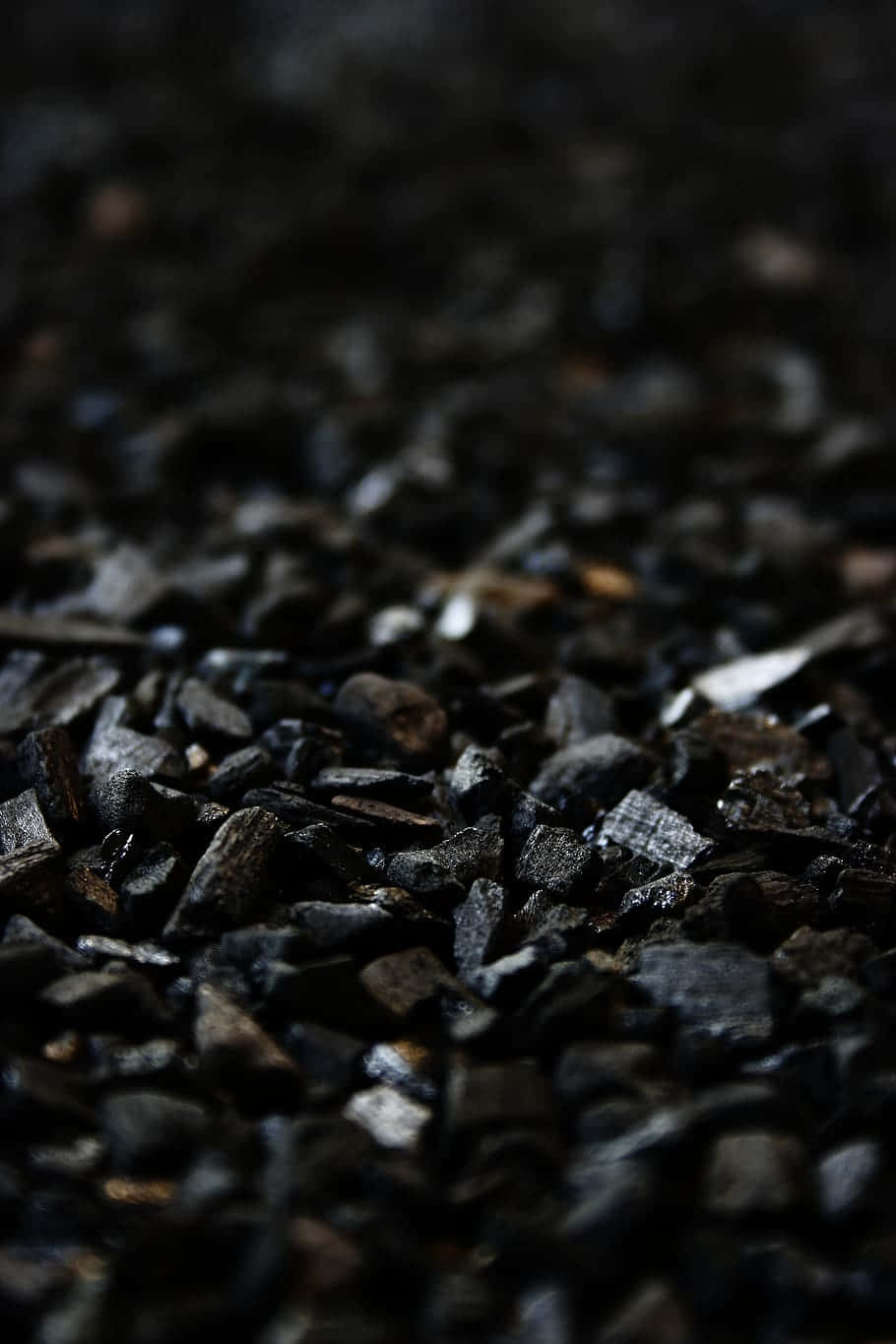 Charcoal 桌布 壁紙 — 暗色紋理木炭碎片的特寫，景深較淺，帶有細微的金屬光澤。