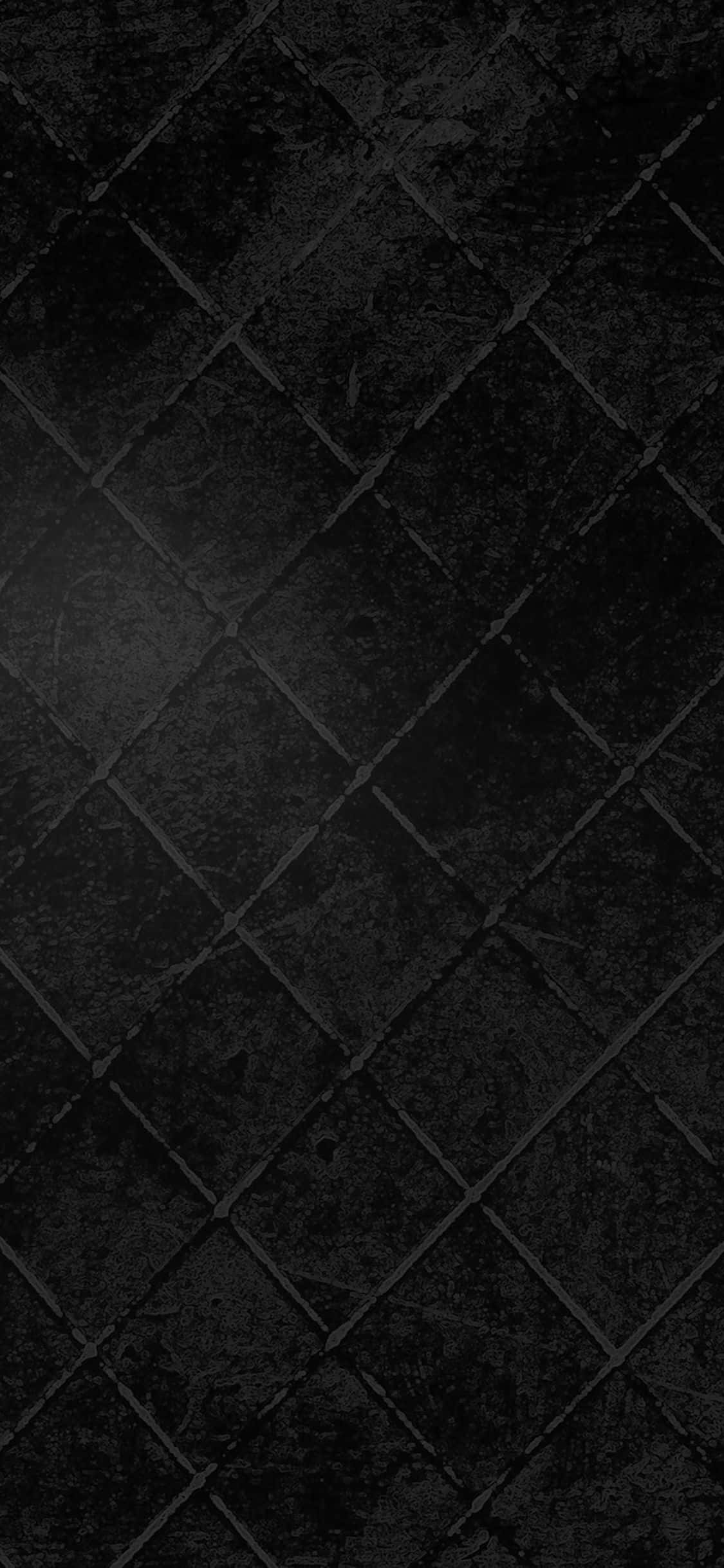 Dark Grunge 桌布 壁紙 — 暗色紋理石磚的特寫，以對角線網格圖案排列，表面有細微磨損。