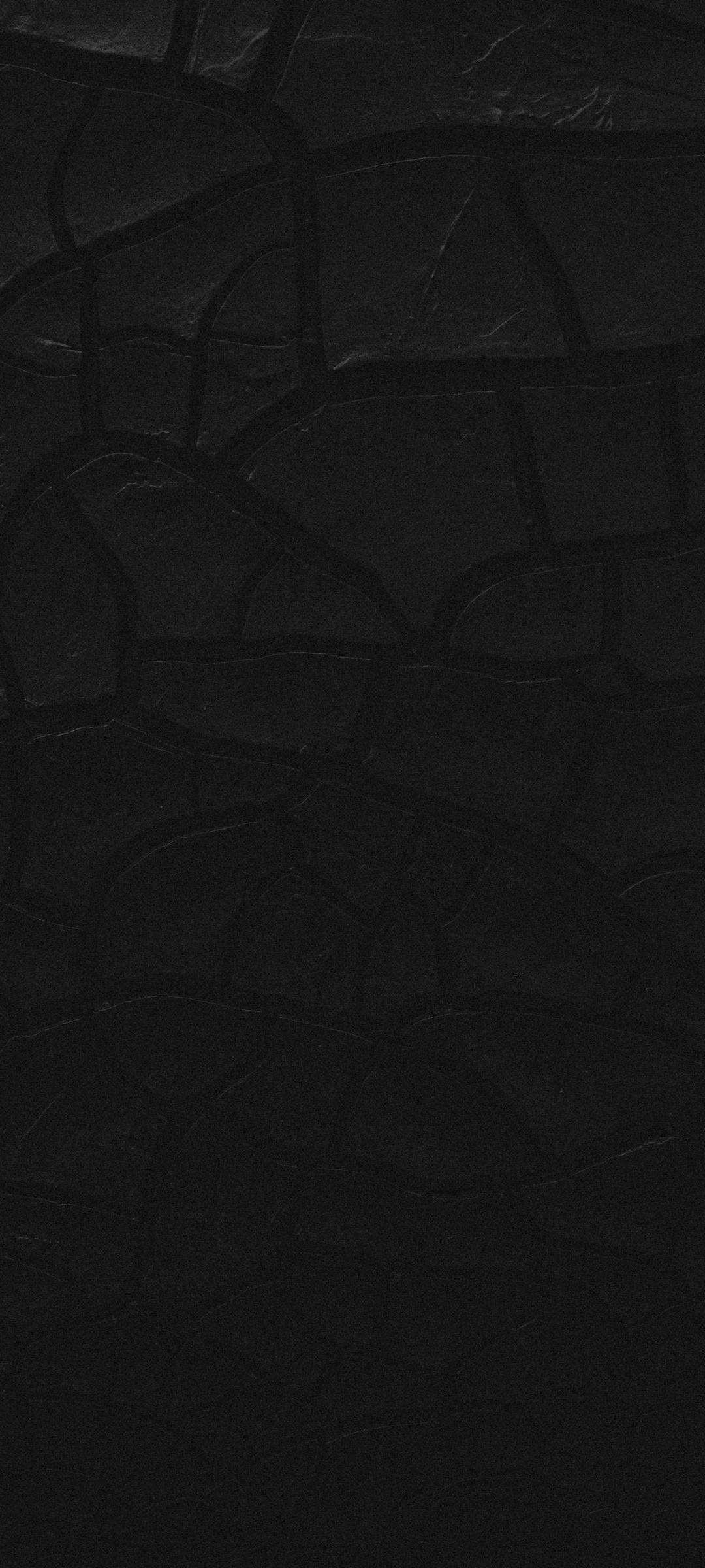 black textured 桌布 壁紙 — 暗色紋理表面的特寫，帶有不規則裂紋圖案，類似乾泥或舊皮革。
