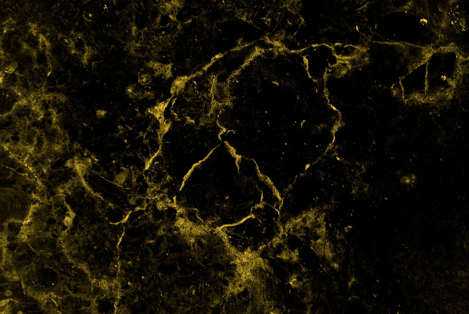 Marble Desktop 桌布 壁紙 — 暗色紋理表面的特寫，帶有發光的金色紋理，形成有機抽象圖案。