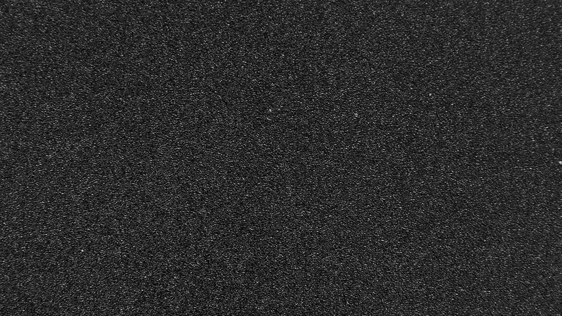 Textured 桌布 壁紙 — 暗色紋理表面的特寫，帶有細小斑點細節和微妙的灰色亮點。