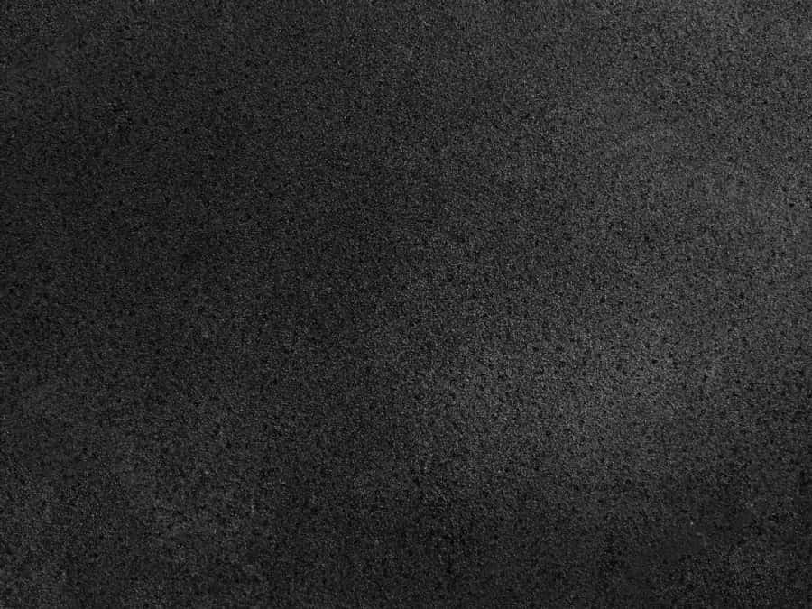 black textured 桌布 壁紙 — 暗色紋理表面的特寫，帶有細微顆粒和柔和漸變照明。