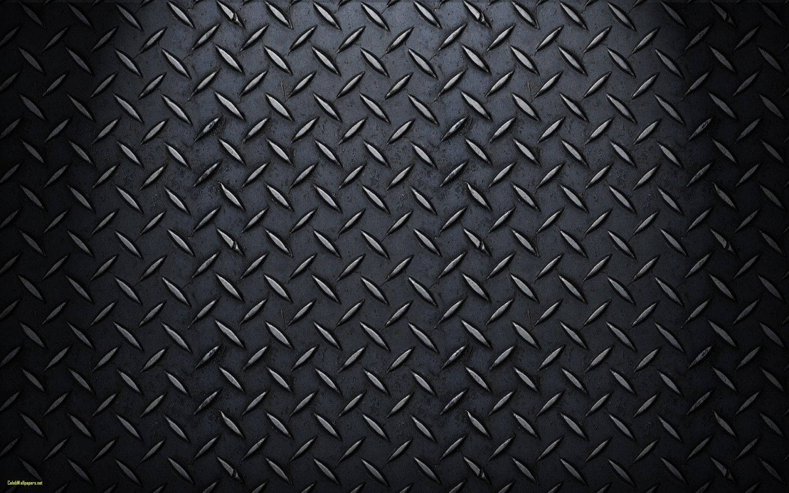 Carbon 桌布 壁紙 — 暗色紋理鑽石板金屬的特寫，柔和光線突出其工業脊線。