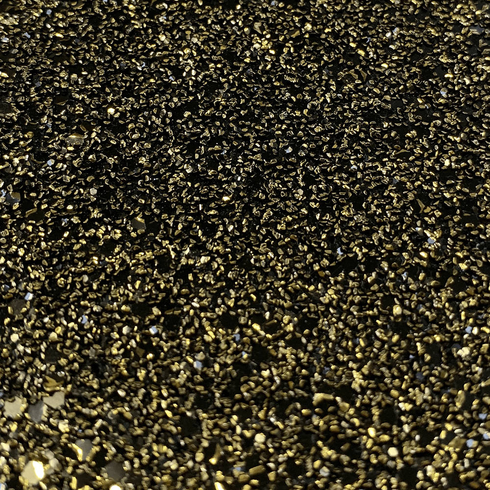 Black And Gold Glitter 桌布 壁紙 — 暗色表面上散落密集金色亮粉顆粒捕捉光線的特寫。