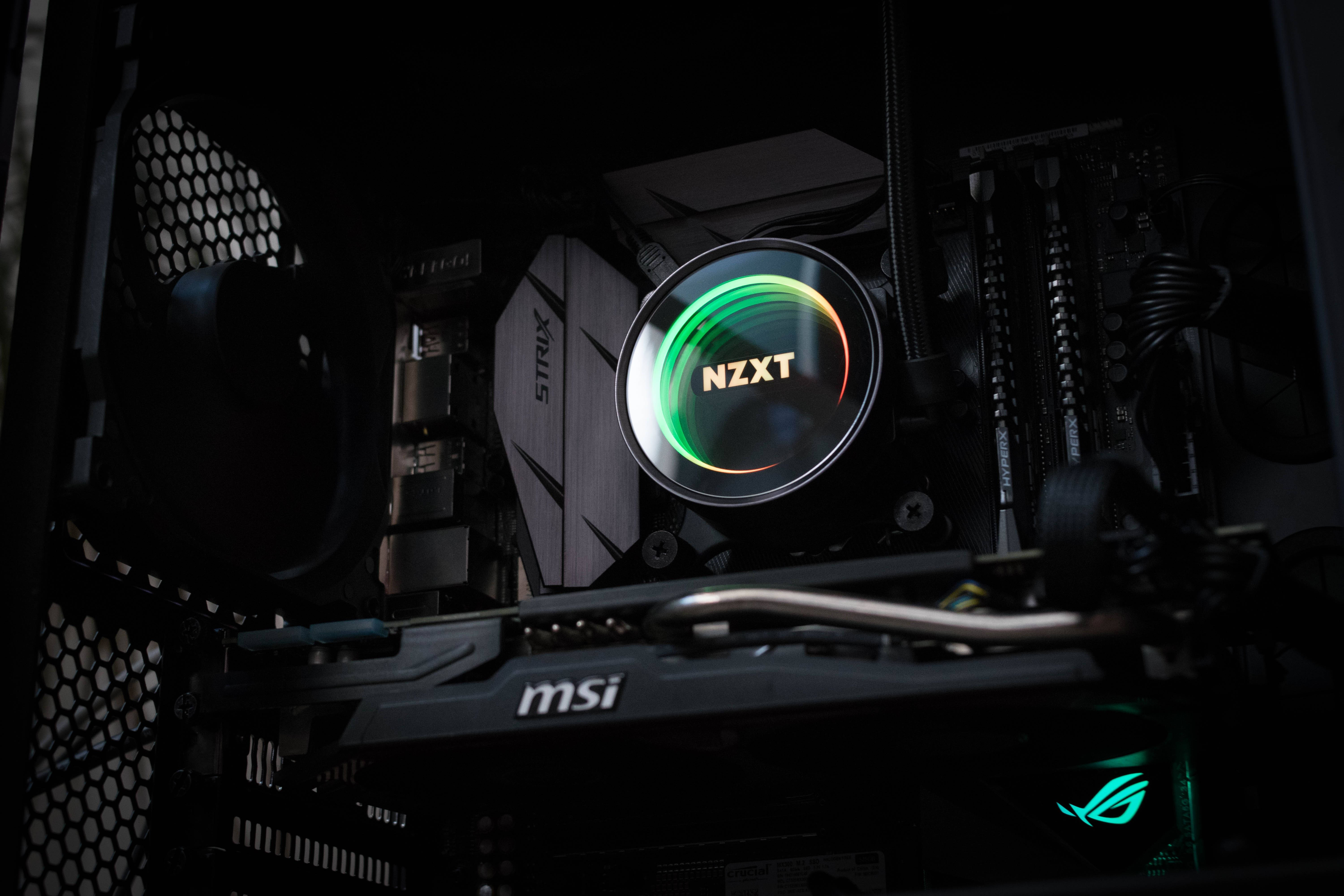 電子 桌布 壁紙 — 暗色電腦機殼內發光的NZXT CPU散熱器特寫，配備MSI主機板和RGB燈光點綴。