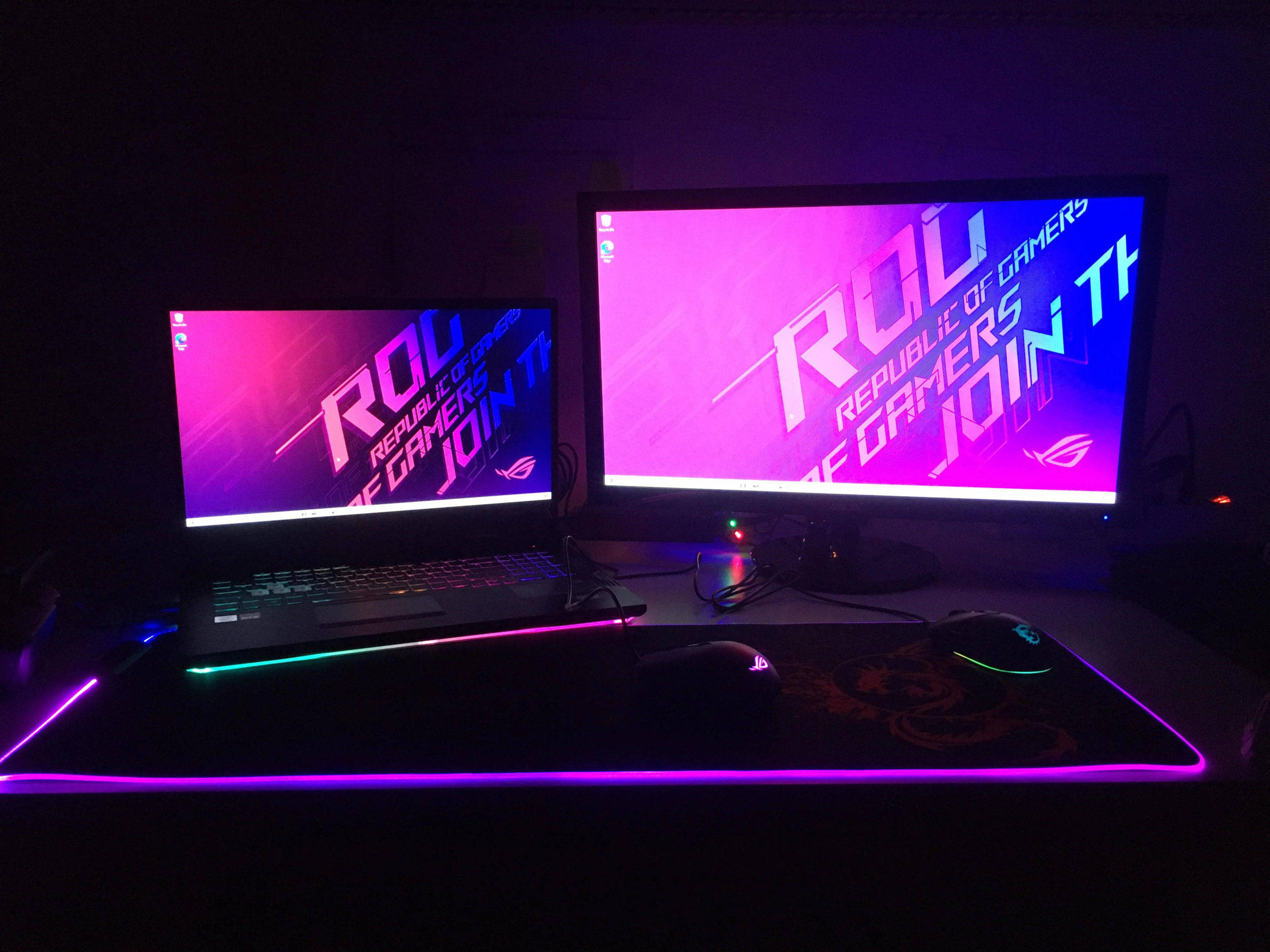 Gaming Setup 桌布 壁紙 — 暗黑房間中，發光RGB筆記型電腦和顯示器展示ROG Republic of Gamers桌面的遊戲設置。