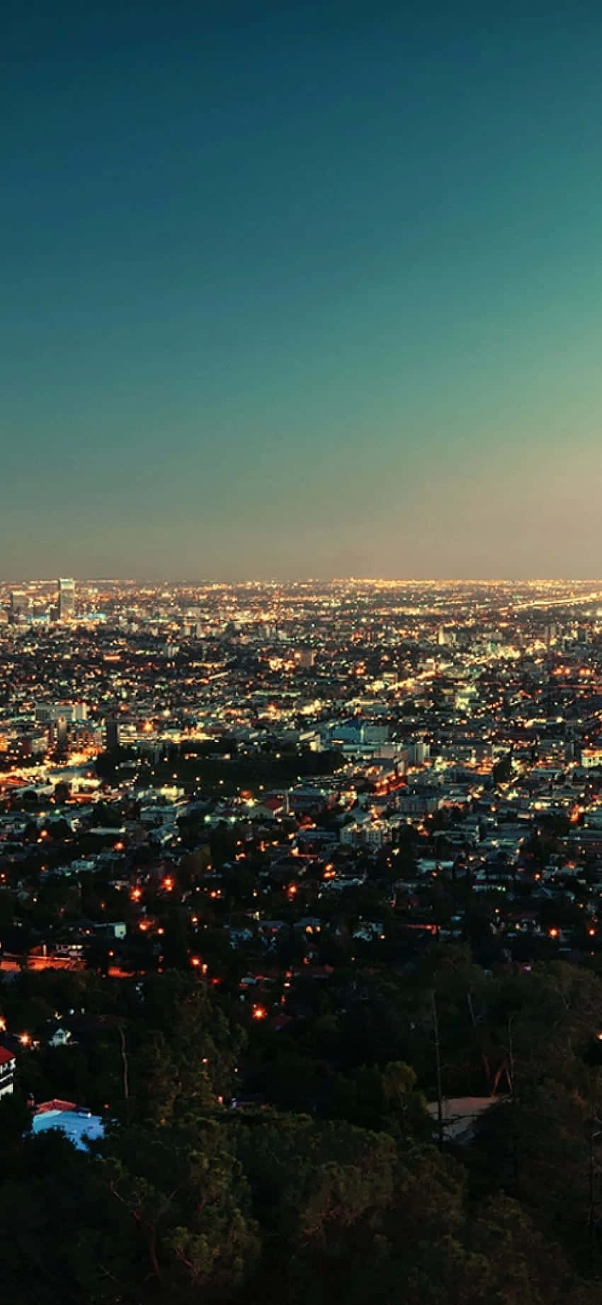 California Aesthetic 桌布 壁紙 — 暮色下，一片廣闊的城市景觀，街道燈光和建築物在漸變的天空下閃耀。