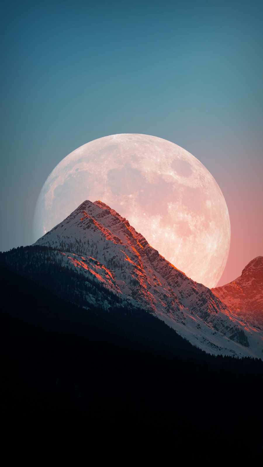 Moon iPhone 桌布 壁紙 — 暮色中，一座積雪的山峰在巨大的粉紅色和藍色發光月亮襯托下呈現剪影。