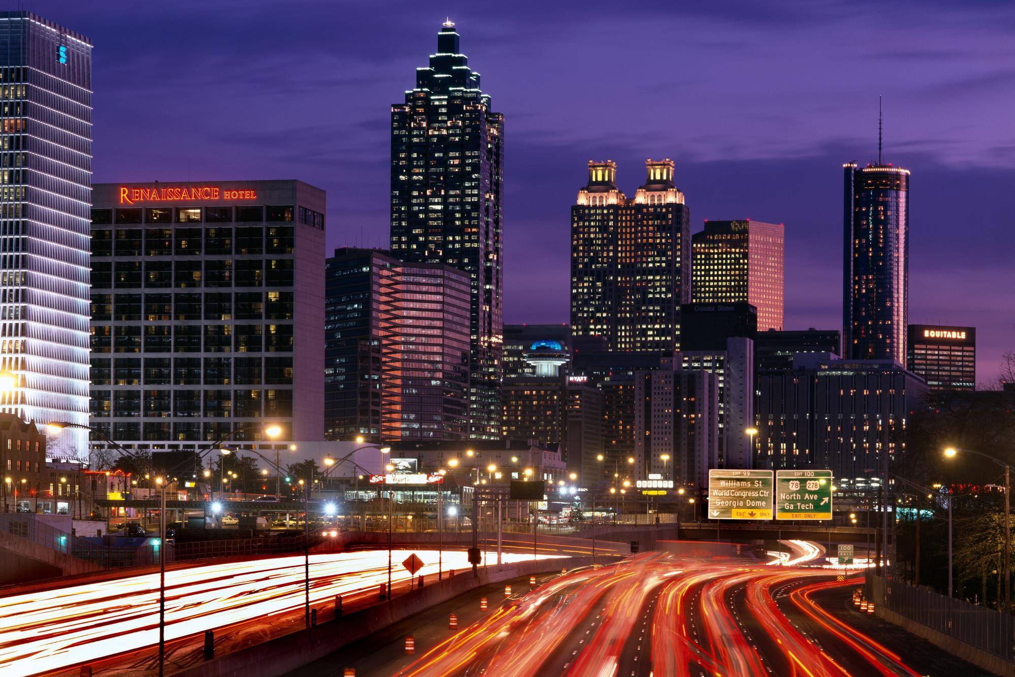 Atlanta 桌布 壁紙 — 暮色中充滿活力的城市天際線，下方高速公路上的車流形成光軌。