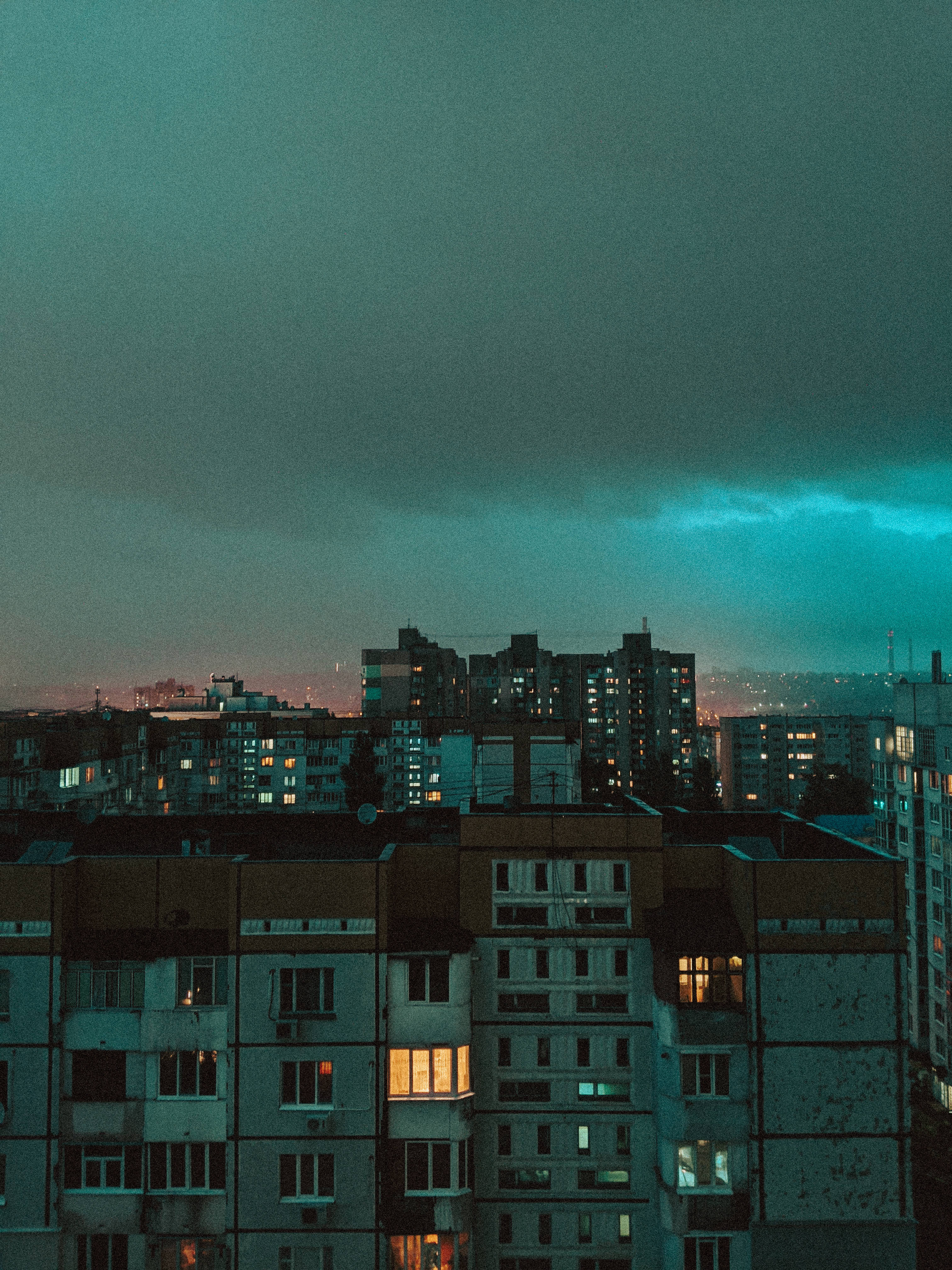 Moldova 桌布 壁紙 — 暮色中的城市景觀，帶有藍綠色天空和公寓窗戶中散發的溫暖燈光。