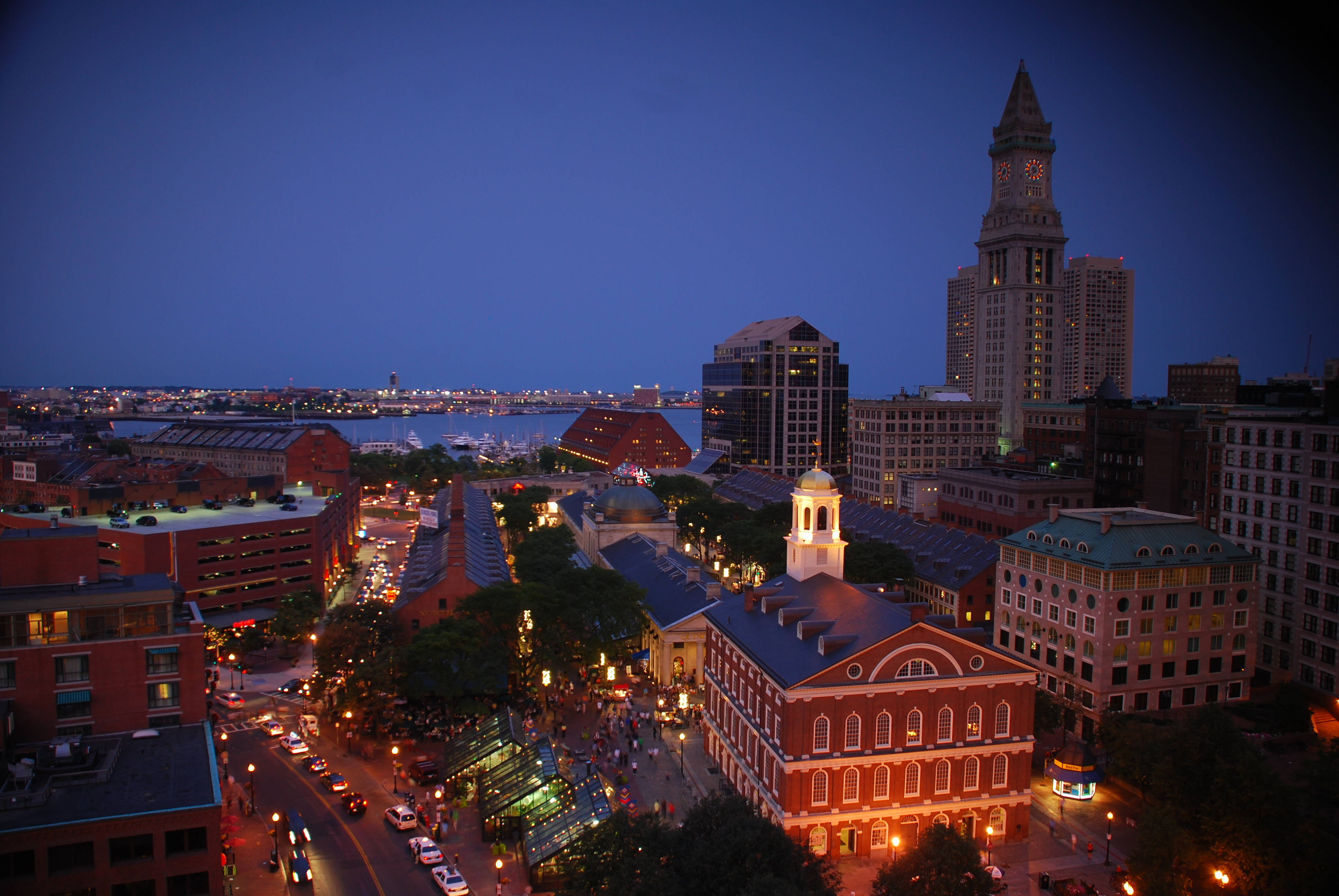 Boston 桌布 壁紙 — 暮色中的城市景觀，歷史悠久的紅磚建築和鐘樓在深藍色天空的映襯下熠熠生輝。