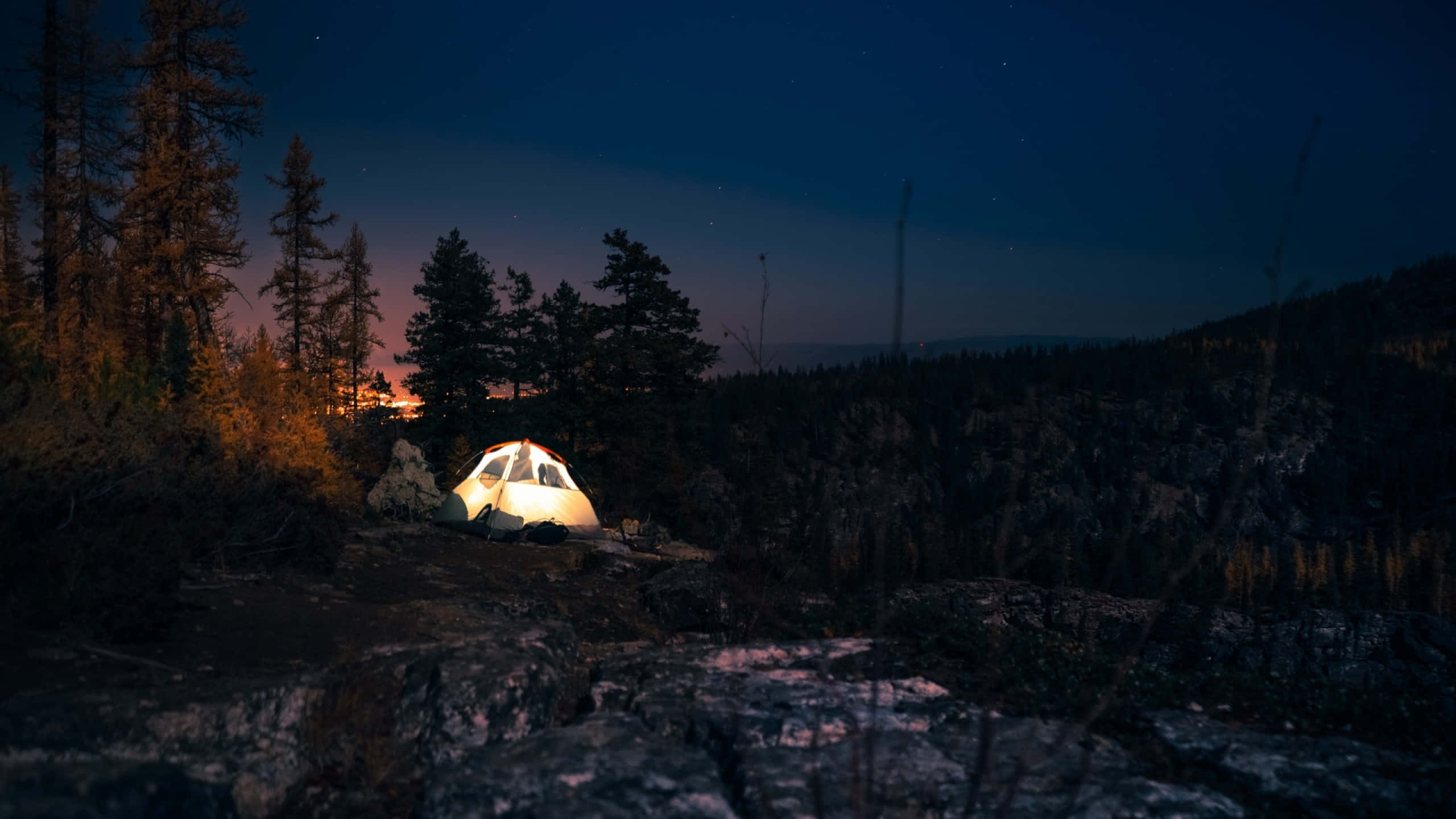 Camping 桌布 壁紙 — 暮色森林中閃爍的帳篷，遠方山丘上星星浮現。