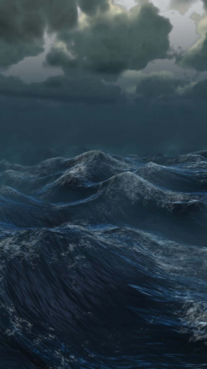 Dark Ocean 桌布 壁紙 — 暴風雨中的海洋，高聳的深藍色波浪在厚重的多雲天空下撞擊。