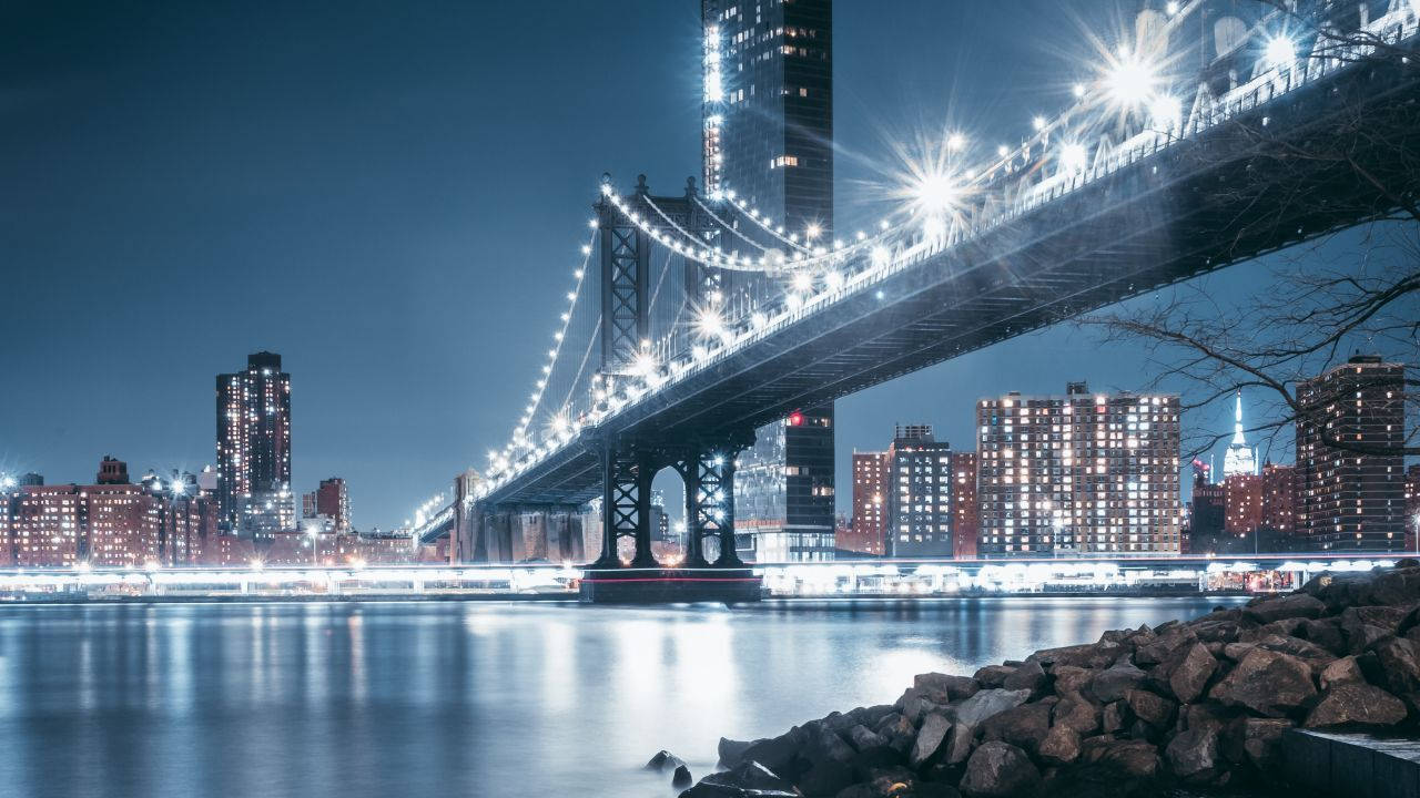 Attraction 桌布 壁紙 — 曼哈頓大橋在水面上的迷人夜景，城市燈光倒映，橋上閃爍的星星。