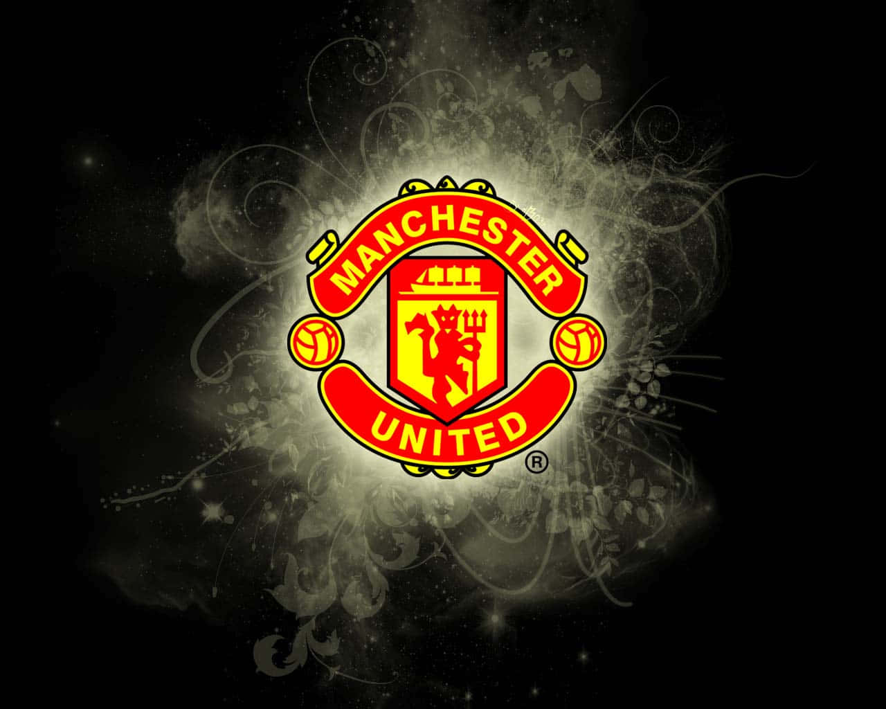 Manchester United Team 桌布 壁紙 — 曼聯會徽在黑暗背景上明亮發光，伴隨著旋轉的銀色煙霧和星形閃光。