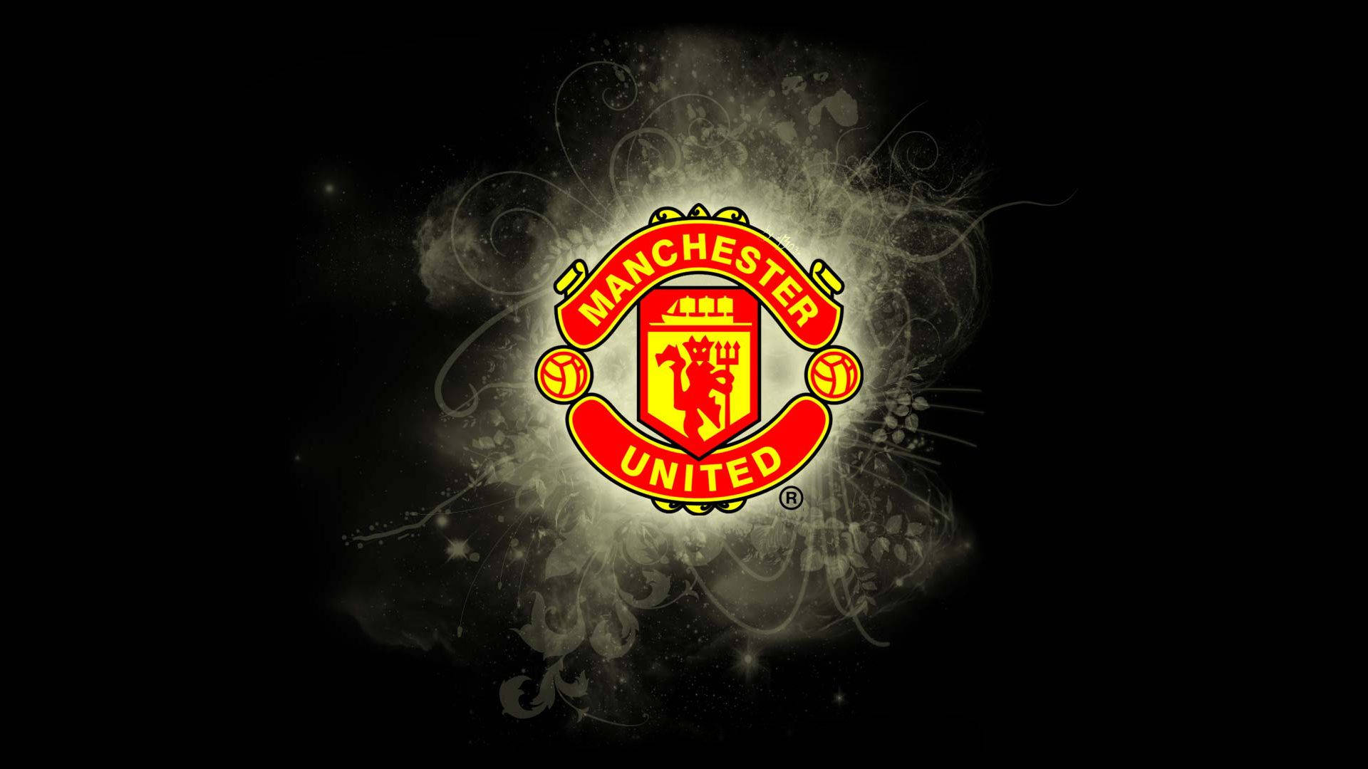 Manchester United Logo 桌布 壁紙 — 曼聯會徽在黑暗背景中，伴隨著旋轉的煙霧和星狀火花，散發出火紅和金色的光芒。