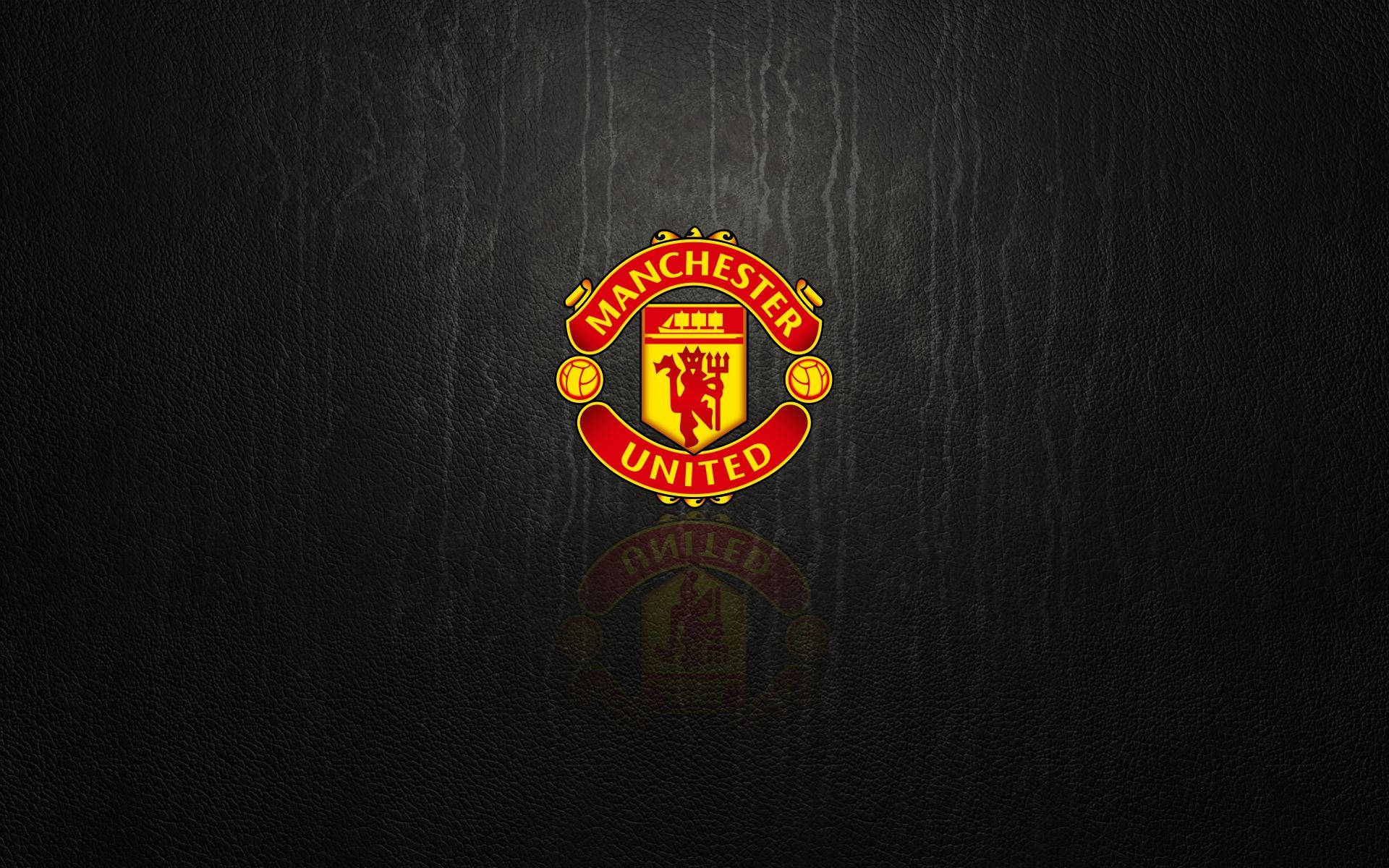 Manchester United Logo 桌布 壁紙 — 曼聯隊徽在帶有紋理的黑色皮革背景上閃耀著紅金色，並帶有微妙的反射效果。