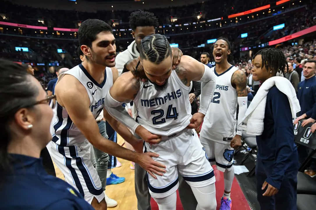 Dillon Brooks 桌布 壁紙 — 曼菲斯灰熊隊球員圍繞著一位身穿白色24號球衣的隊友，他在籃球場上痛苦地彎下腰。