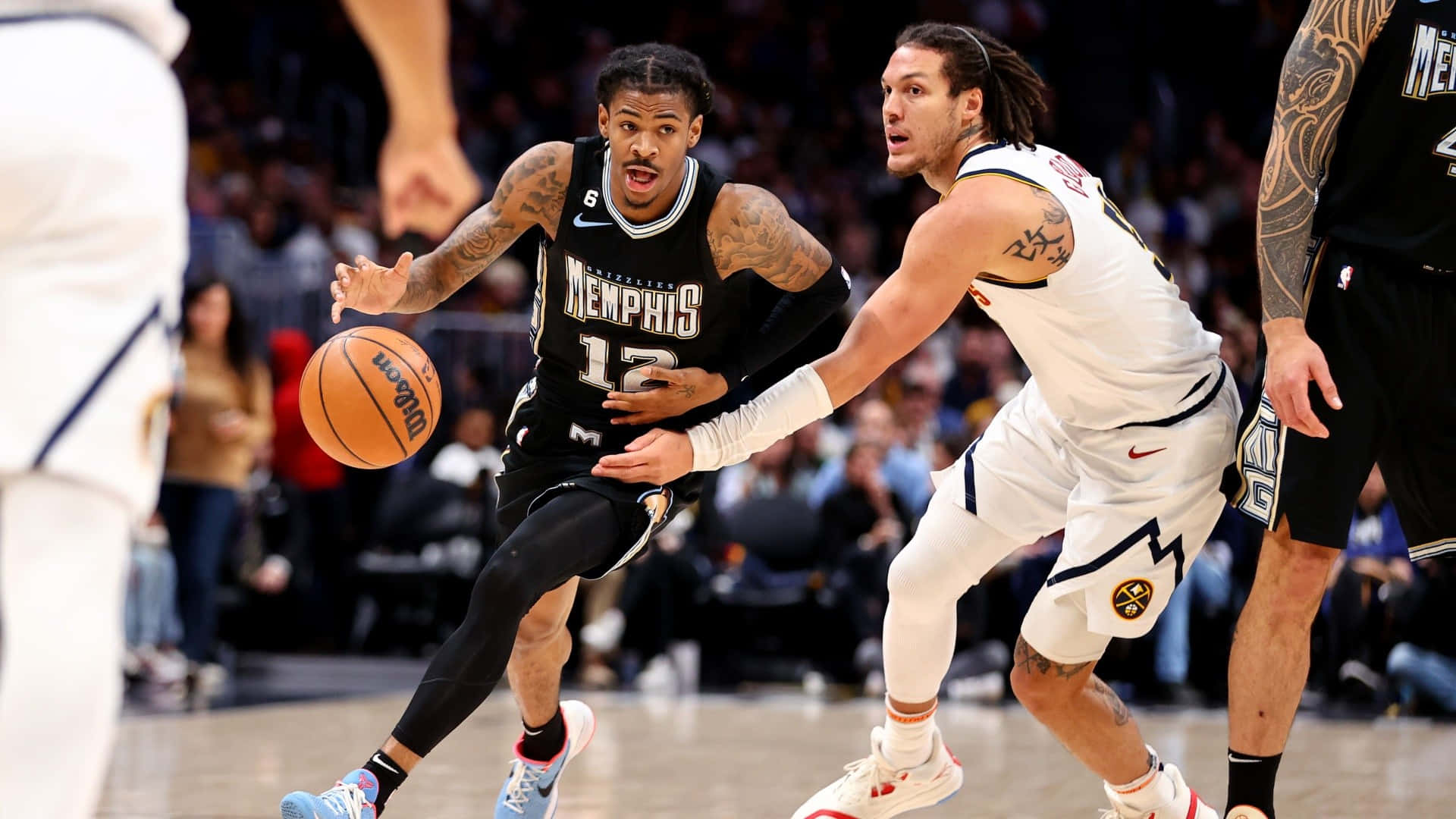 Ja Morant 動圖 桌布 壁紙 — 曼菲斯灰熊隊球員在激烈的NBA比賽中運球，同時被丹佛金塊隊球員緊密防守。
