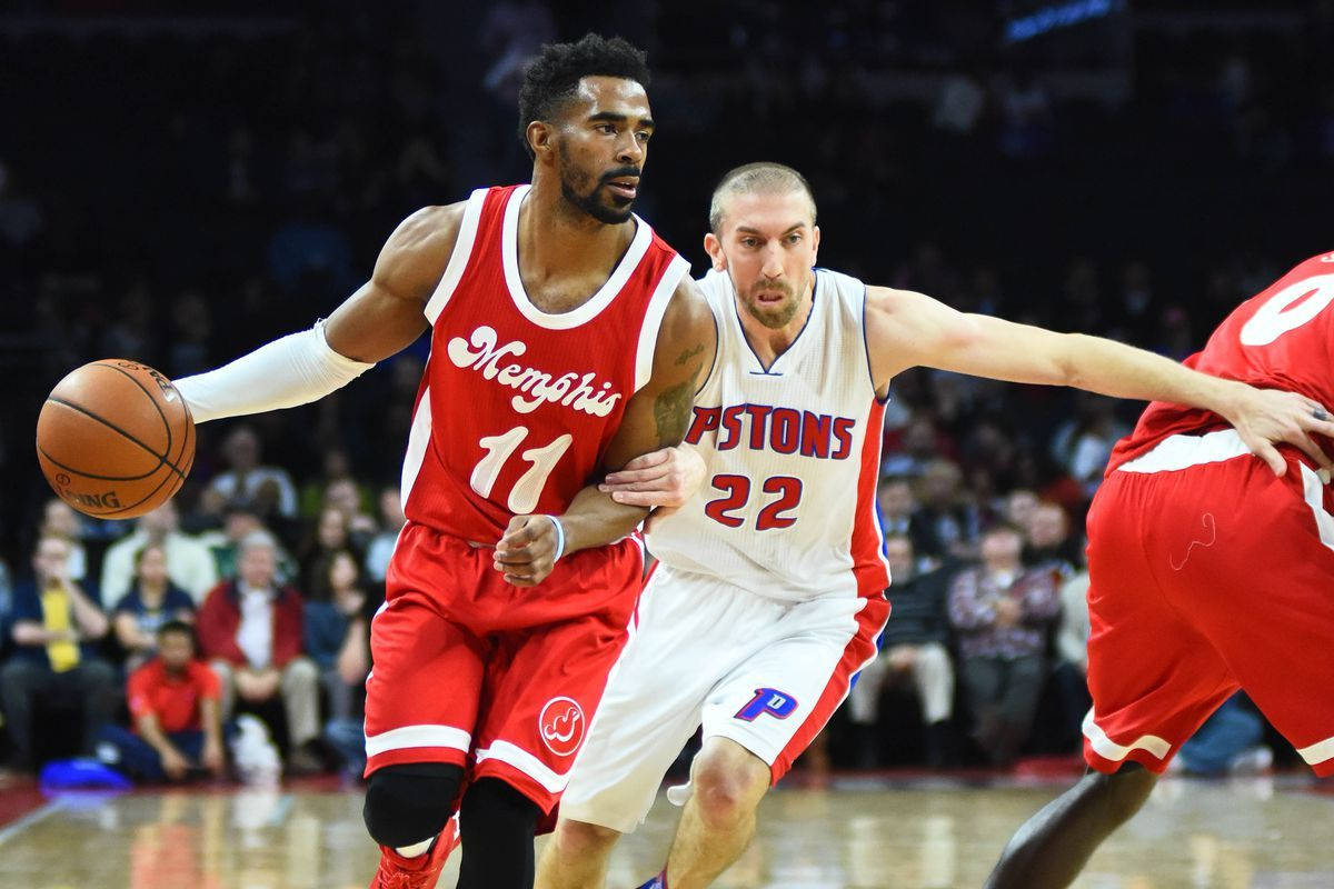 mike conley 桌布 壁紙 — 曼菲斯灰熊隊球員在激烈的NBA比賽中運球，同時被底特律活塞隊球員緊密防守。