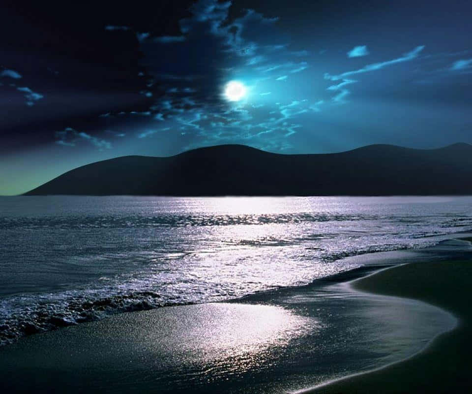 Beach At Night 桌布 壁紙 — 月光在寧靜的海洋上閃爍，波浪在黑暗多雲的天空下拍打著彎曲的海岸。