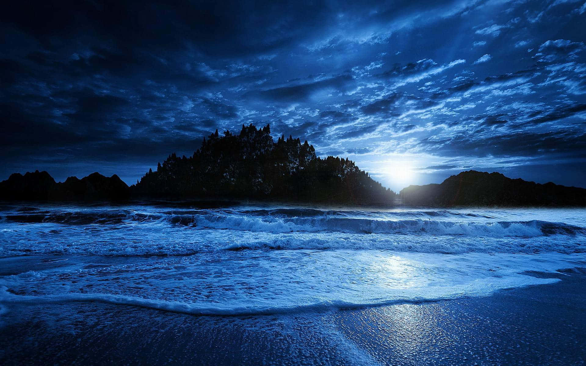 Beach At Night 桌布 壁紙 — 月光穿過暴風雲層，照耀著波濤洶湧的海洋，拍打著黑暗的岩石海岸。