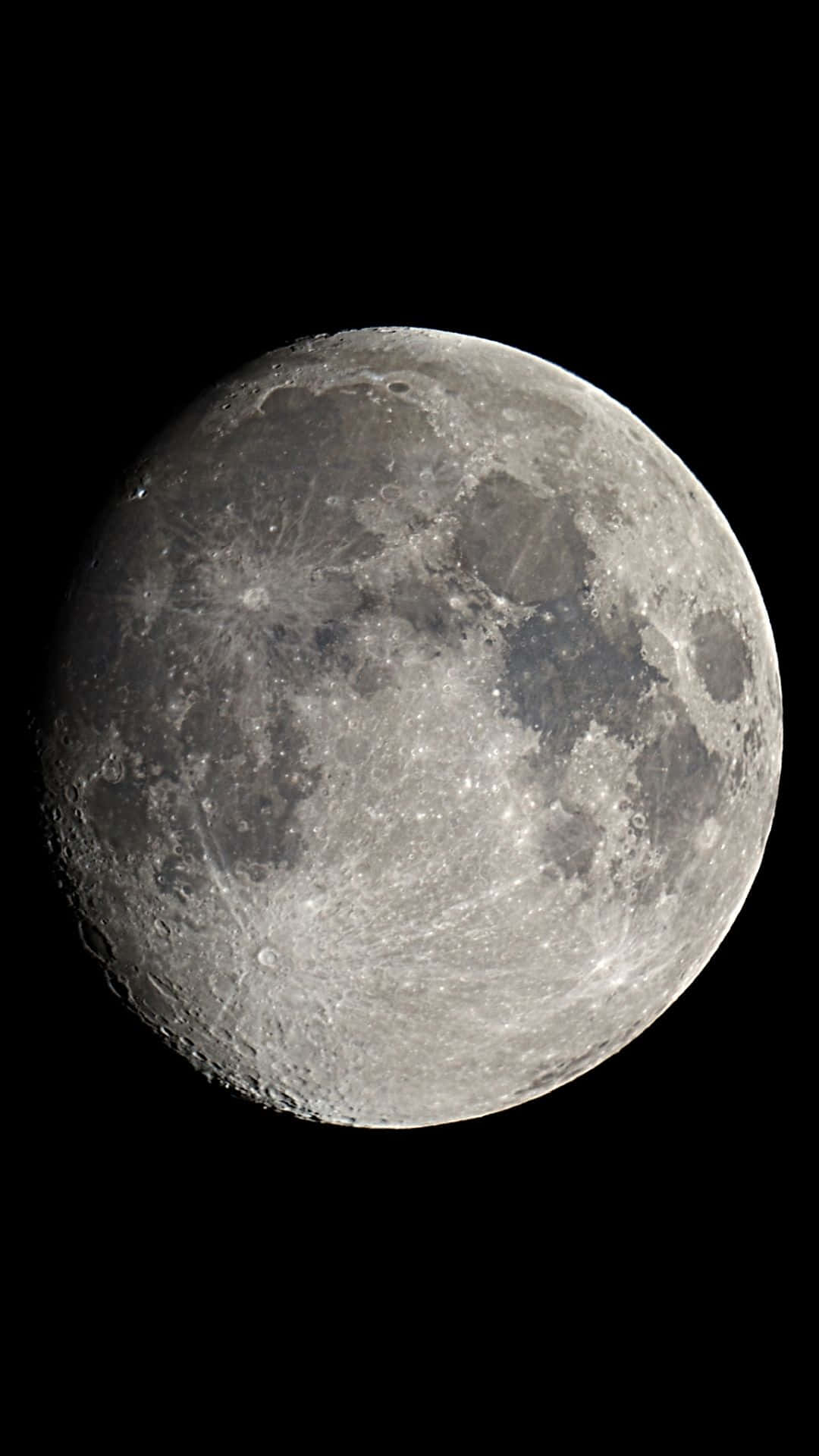 Moon iPhone 桌布 壁紙 — 月球佈滿隕石坑的灰色表面在漆黑天空中發光的詳細特寫。