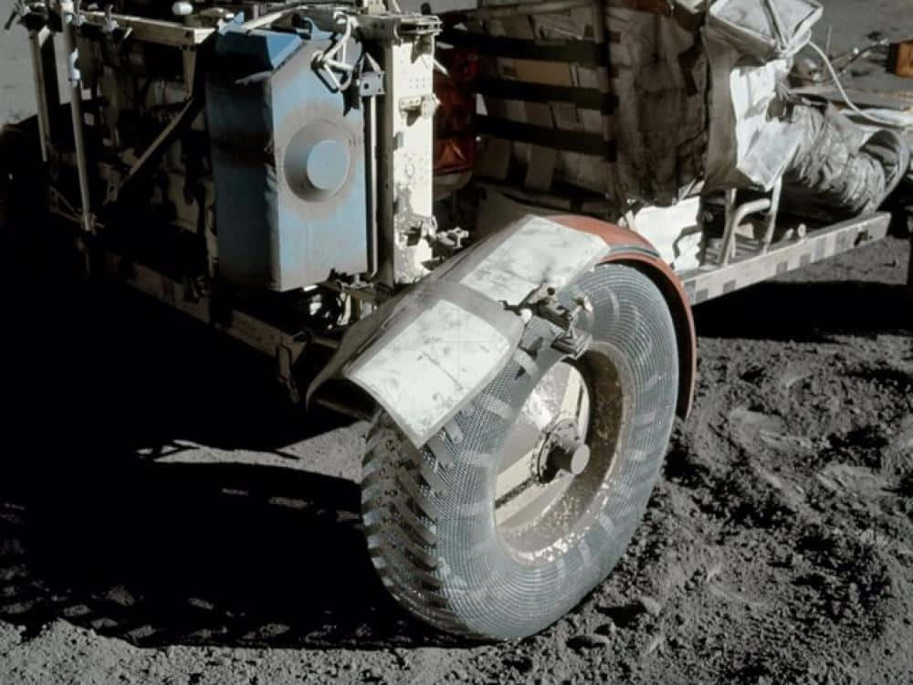 Lunar Rover 桌布 壁紙 — 月球探測車車輪的特寫，嵌入灰色月球塵埃中，在明亮陽光下帶有銳利陰影。