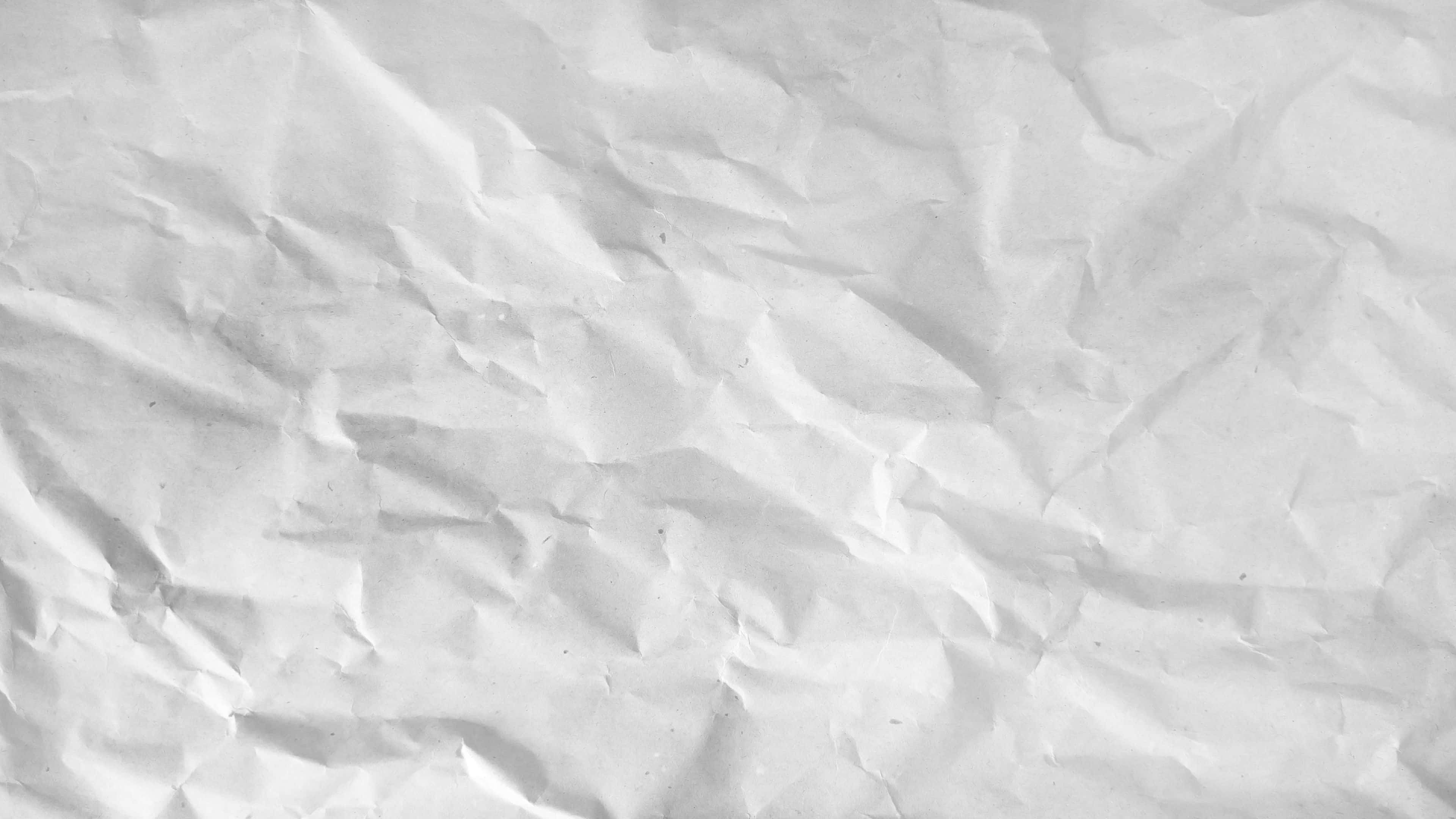 Textures 桌布 壁紙 — 有紋理的白色皺紙特寫，帶有柔和陰影和微妙摺痕。