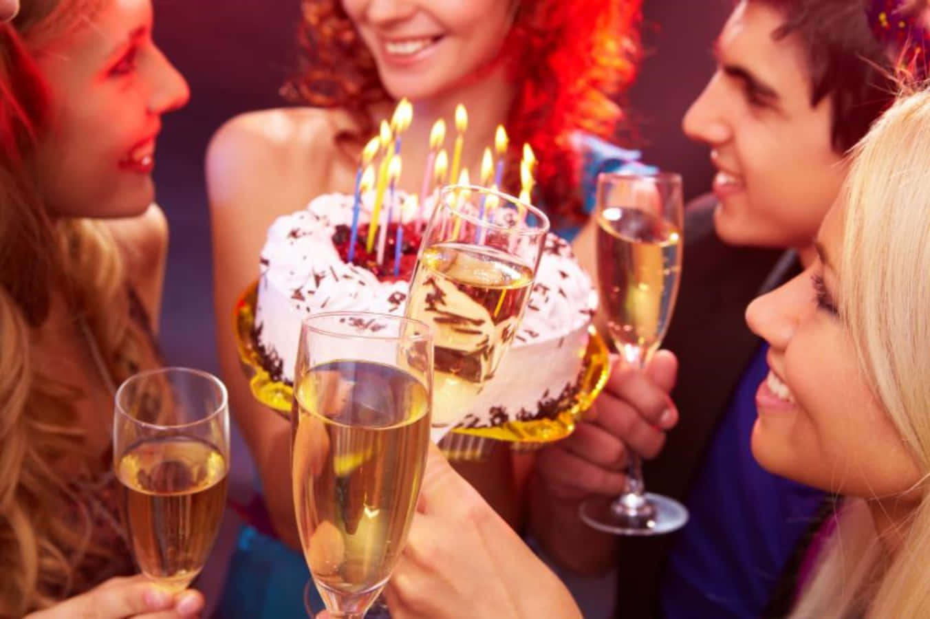 Birthday Celebration 桌布 壁紙 — 朋友們圍繞著生日蛋糕，點燃蠟燭和香檳杯，進行節日慶祝。