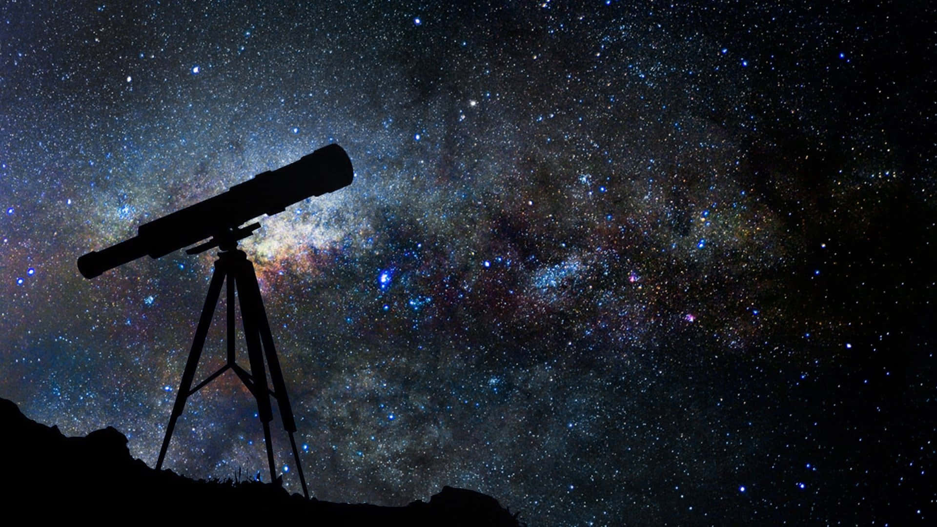 astronomy 桌布 壁紙 — 望遠鏡的剪影矗立在山丘上，背景是充滿宇宙塵埃和發光星雲的 vibrant 星空夜空。