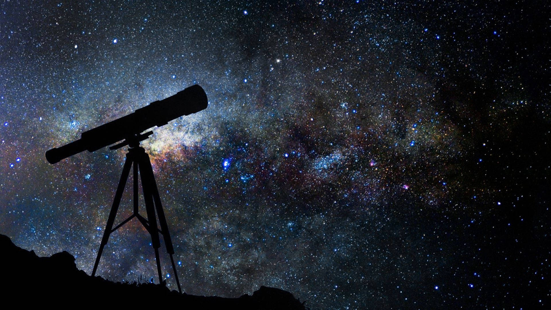 夜空 桌布 壁紙 — 望遠鏡的剪影矗立在山丘上，背景是充滿宇宙塵埃和發光星雲的 vibrant 星空夜空。