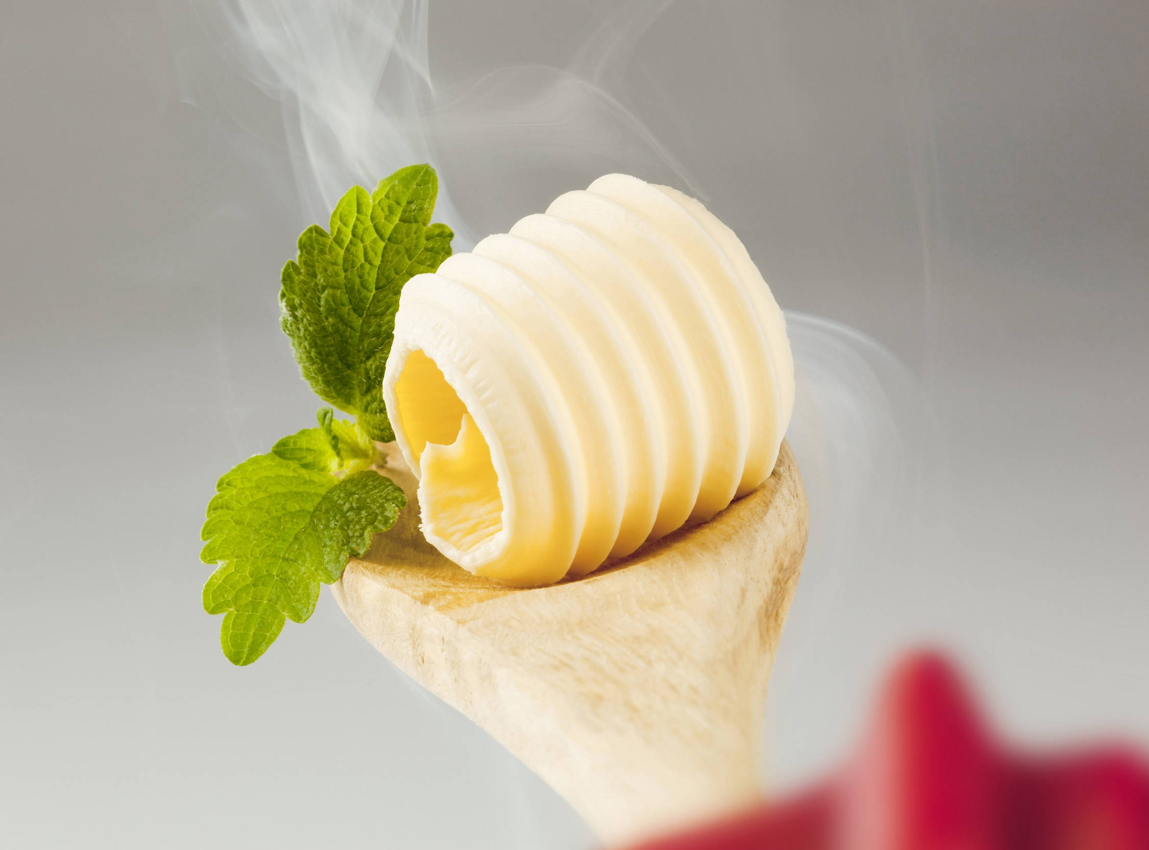 Food Photography 桌布 壁紙 — 木匙上的奶油狀牛油漩渦，搭配新鮮薄荷葉和縷縷蒸氣，在柔和灰色背景前升起。