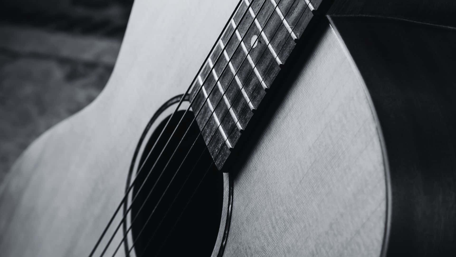Black And White Guitar 桌布 壁紙 — 木吉他琴身及指板的單色特寫，清晰聚焦於木紋和琴弦。
