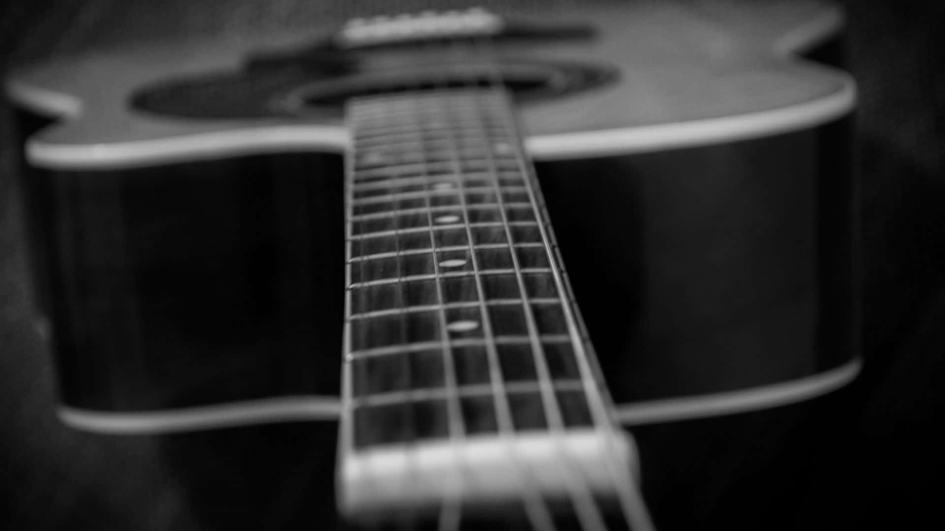 Black And White Guitar 桌布 壁紙 — 木吉他的指板與琴身黑白特寫，景深較淺。