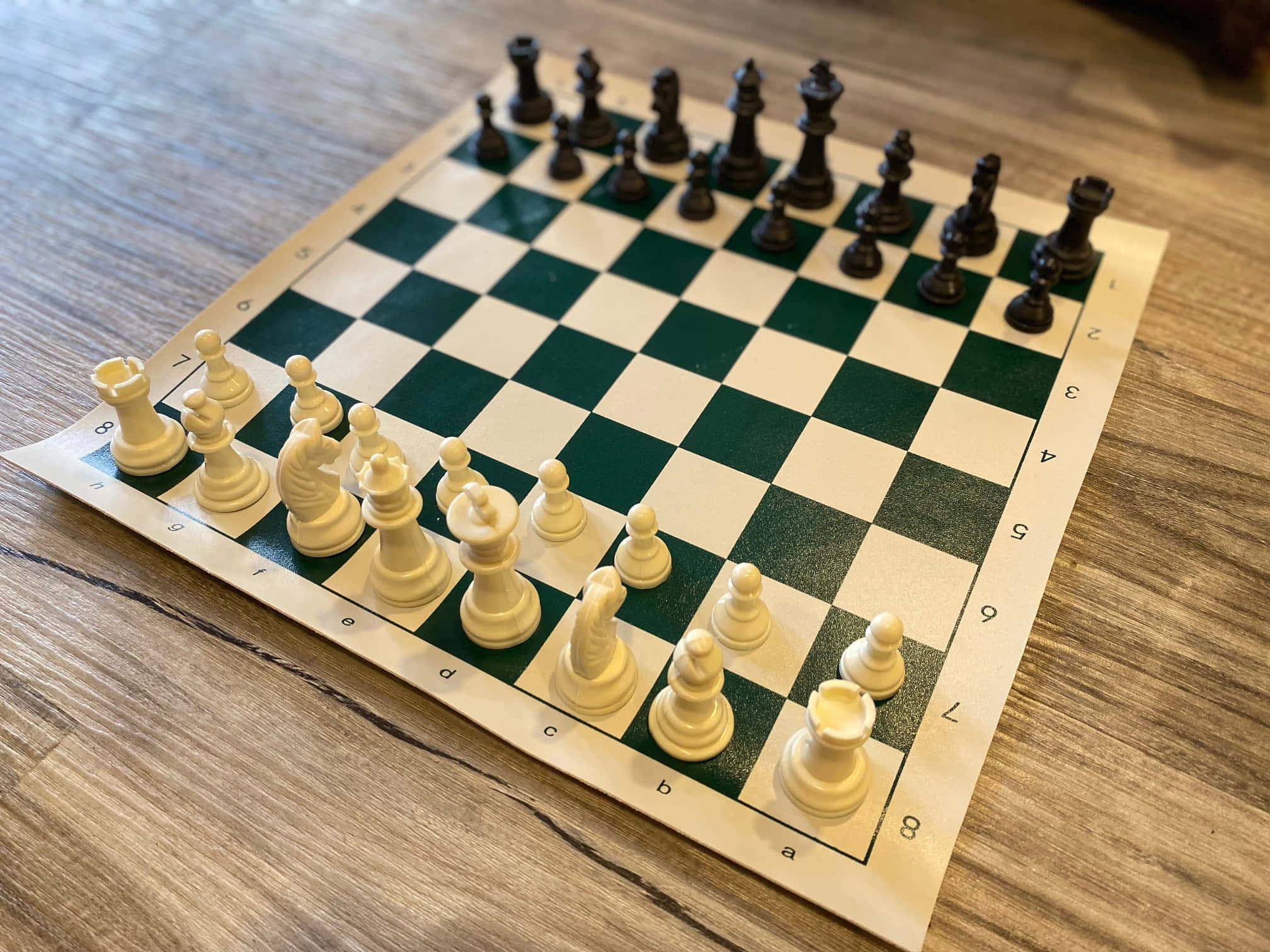 Chessboard 桌布 壁紙 — 木地板上黑白棋子擺好準備對弈的棋盤特寫。