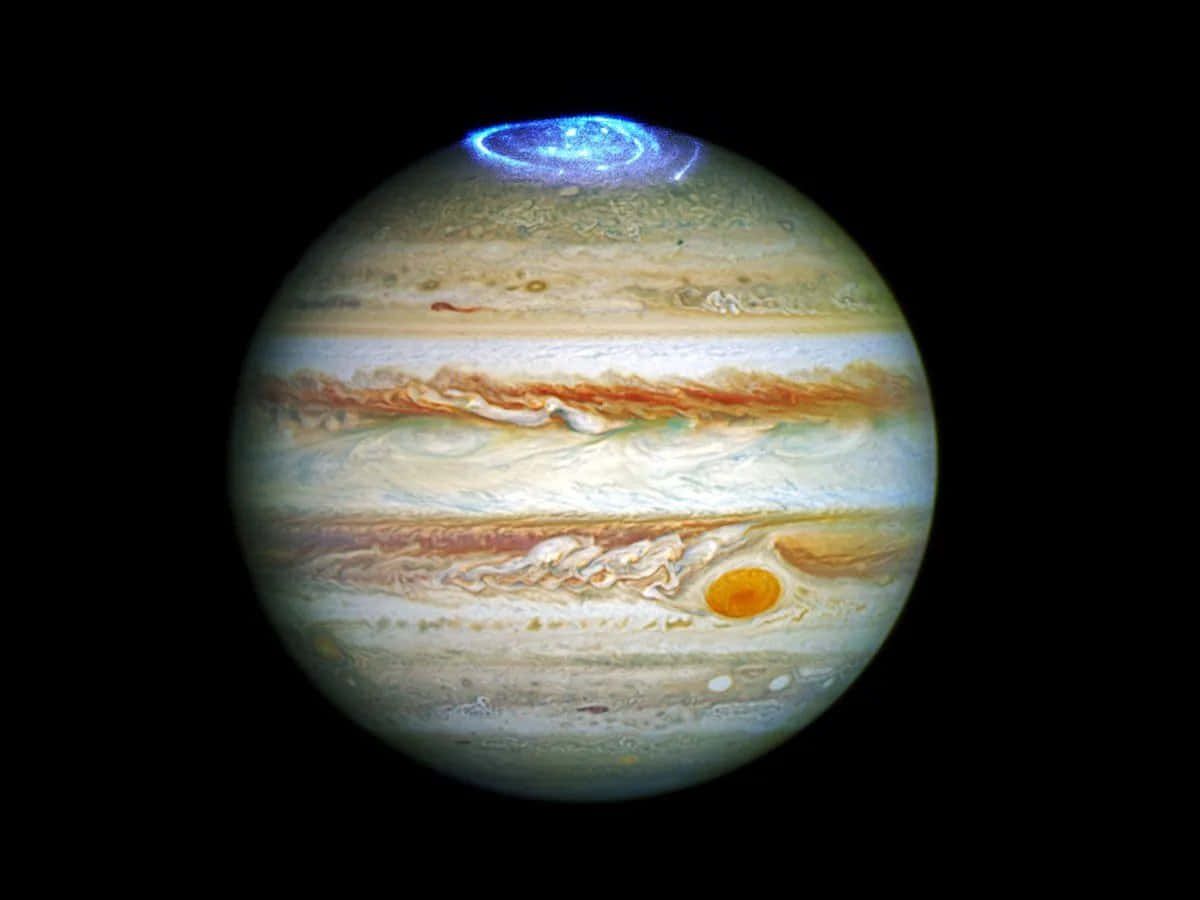 木星 桌布 壁紙 — 木星行星，帶有漩渦狀的米色、橙色和白色雲帶，以及一個發光的藍色極地風暴，背景是黑色太空。