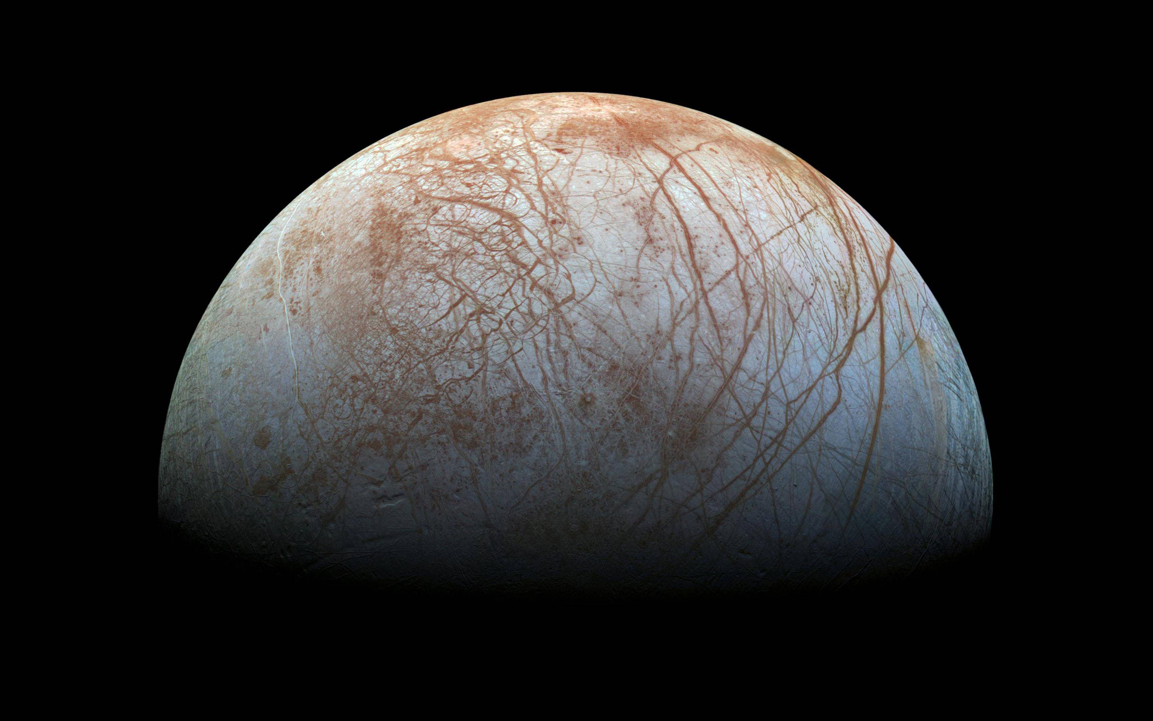 外太空 桌布 壁紙 — 木星衛星歐羅巴的特寫，在黑色太空背景下，其冰冷的藍白色表面顯露出複雜的紅褐色裂縫。