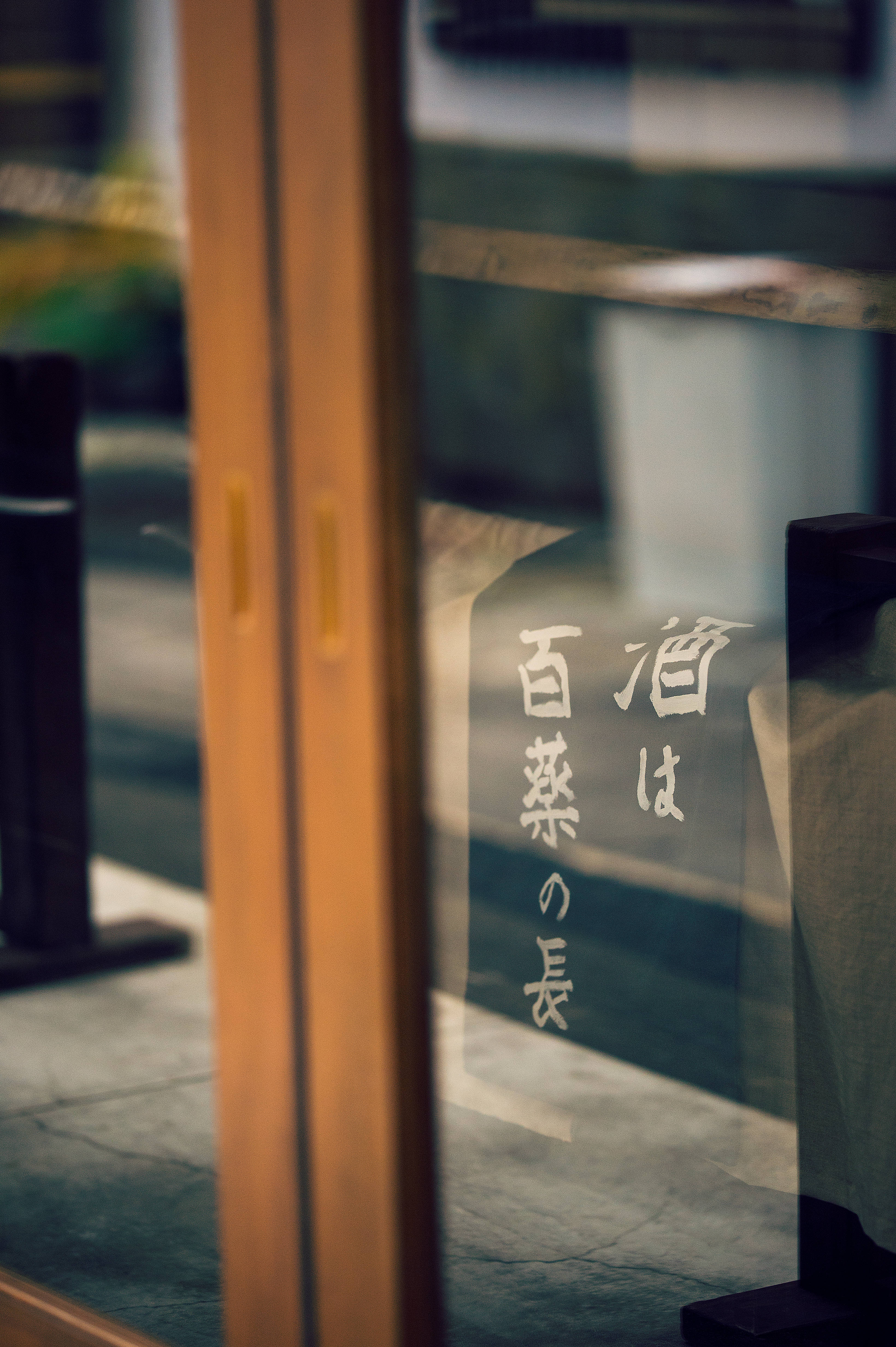 Transparent 桌布 壁紙 — 木框玻璃門的特寫，帶有日本書法，反射出模糊的街景。