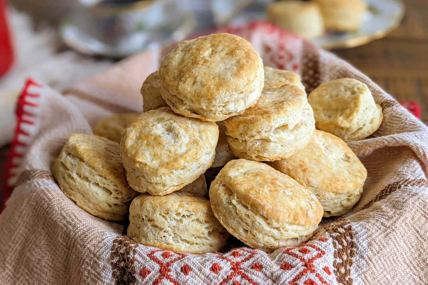 Biscuit 桌布 壁紙 — 木桌上一個有圖案的布籃裡，放著一堆溫暖的金黃色自製餅乾。