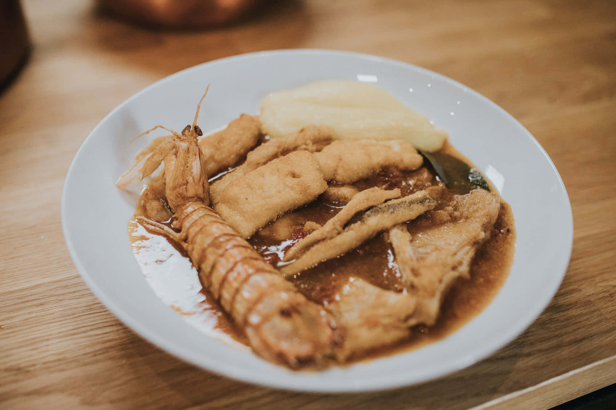 Croatia 桌布 壁紙 — 木桌上白色盤子盛裝炸蝦天婦羅和魚塊，搭配美味棕色醬汁的特寫。