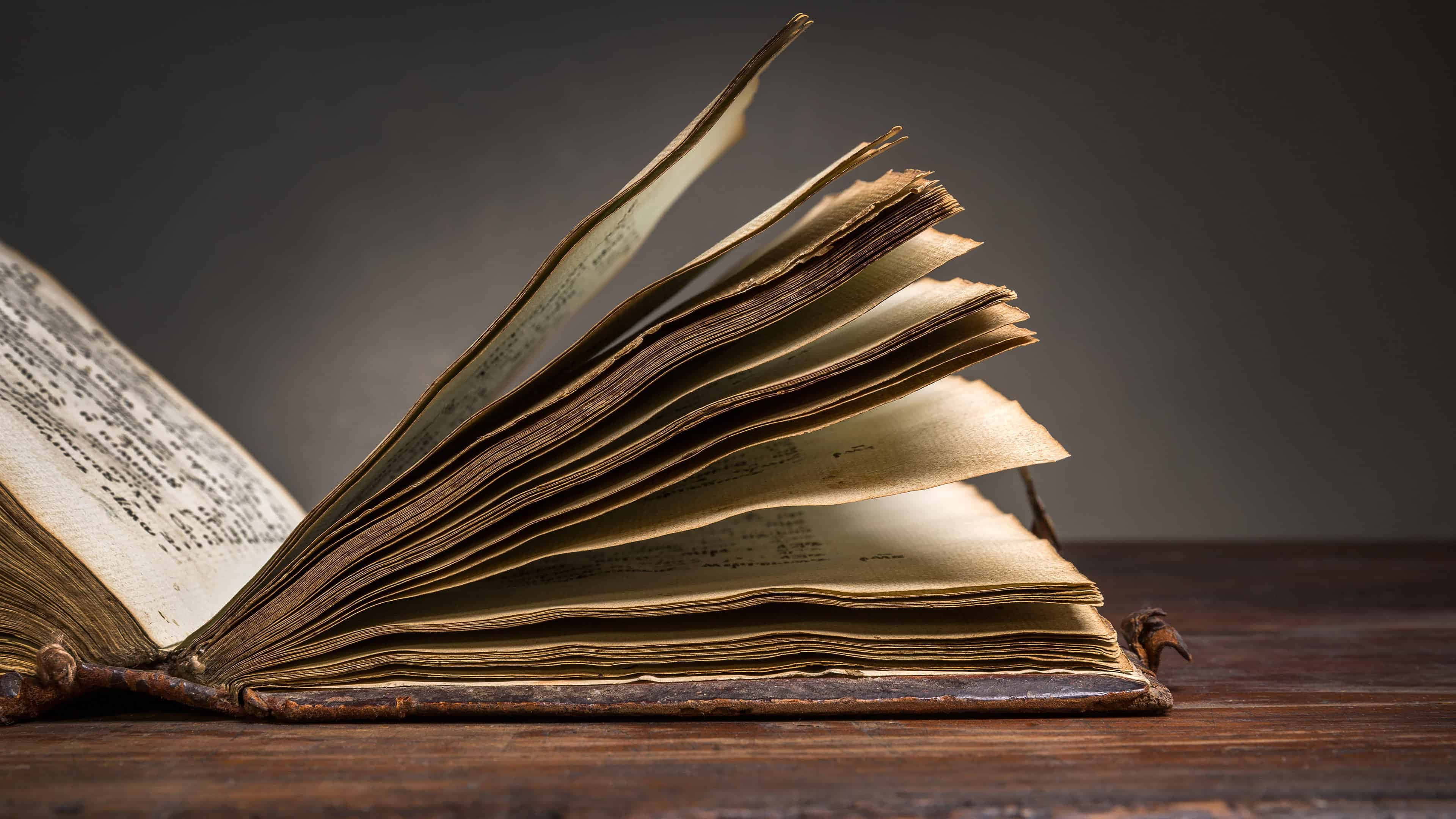 木桌上的一本翻開的書 壁紙