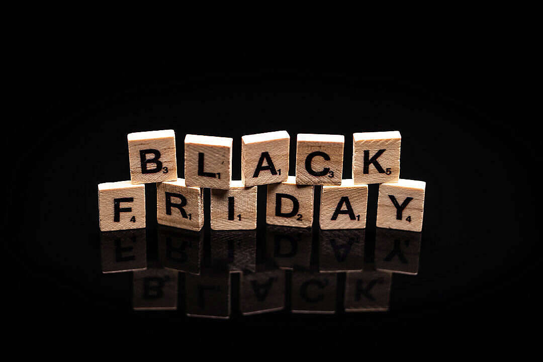黑色高畫質桌布 桌布 壁紙 — 木製 Scrabble 字母牌拼出 BLACK FRIDAY，立於光滑黑色表面上，反射清晰。