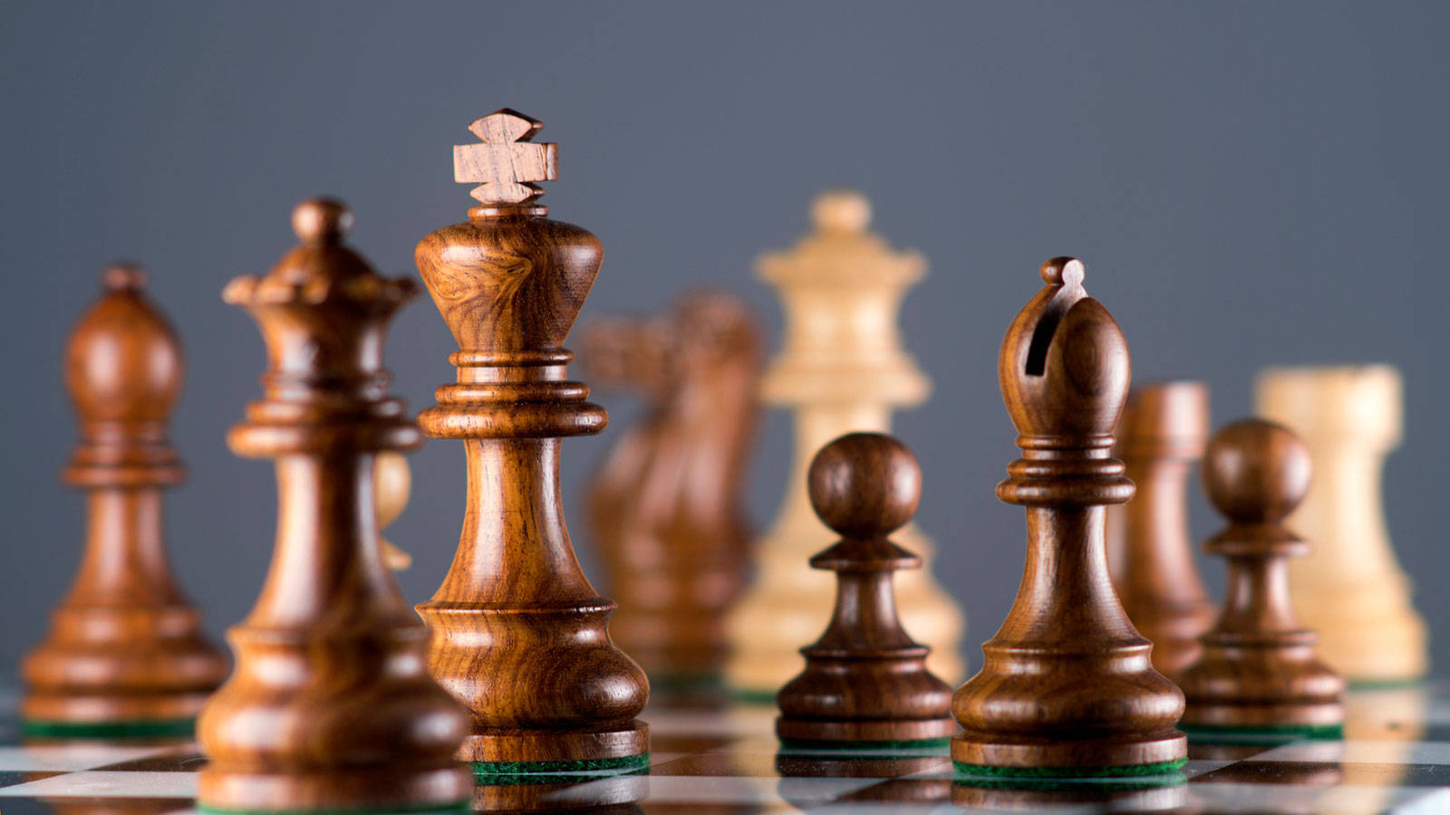 西洋棋 桌布 壁紙 — 木製國際象棋棋子喺棋盤上嘅特寫，淺景深，灰色背景。