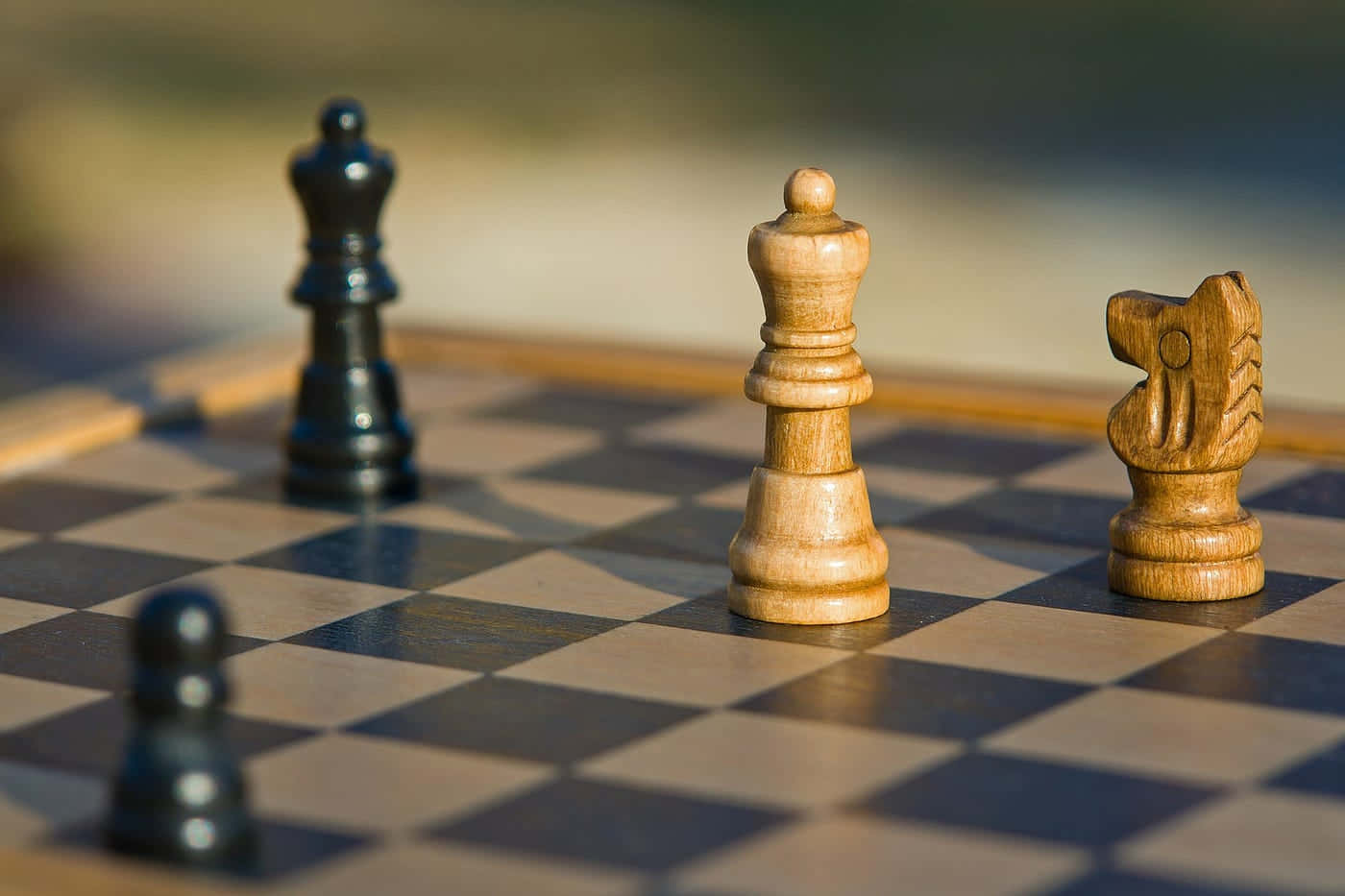 Chessboard 桌布 壁紙 — 木製國際象棋棋子於方格棋盤上的特寫，柔和陽光投射陰影。