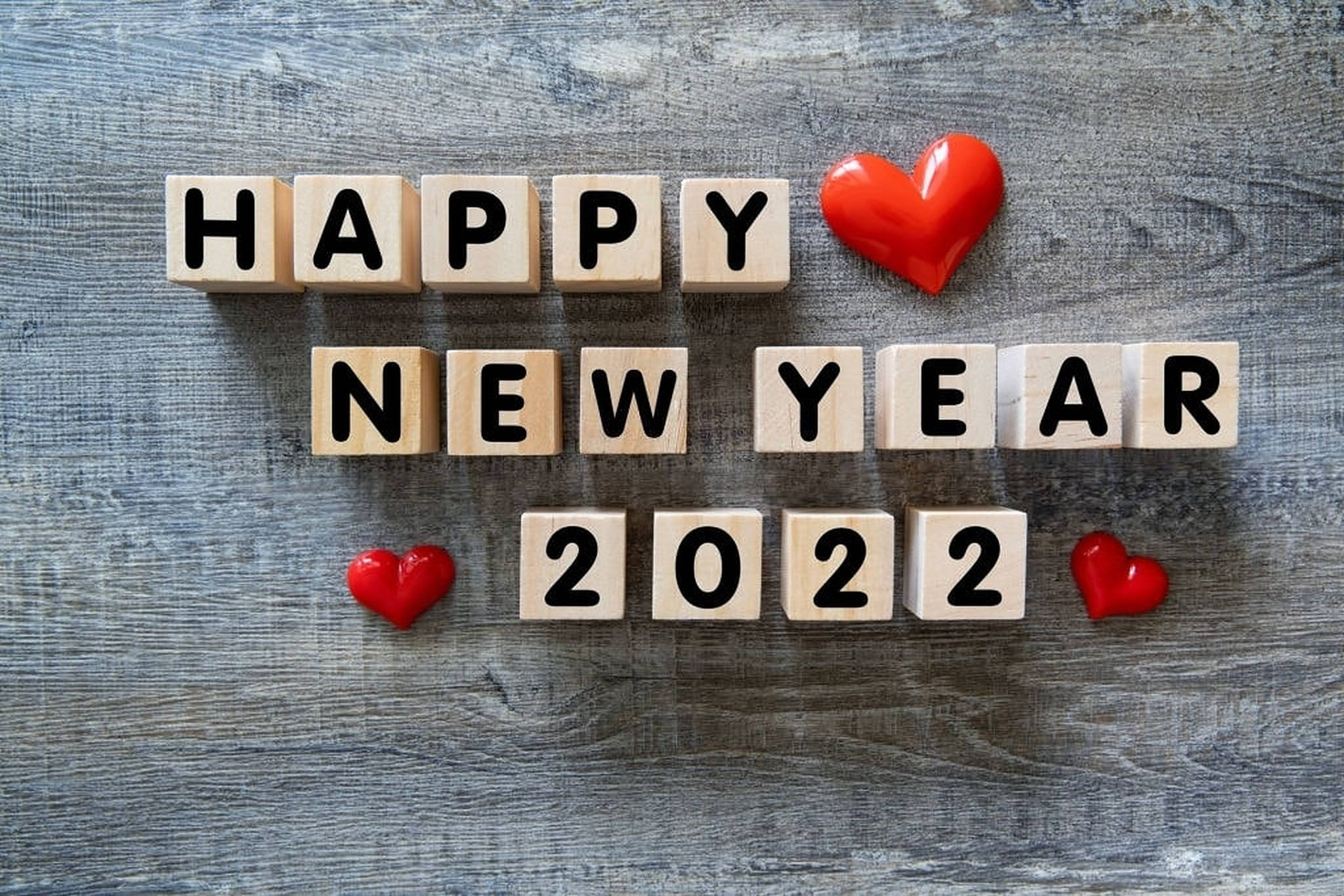 New 桌布 壁紙 — 木製積木在灰色木面上拼出「HAPPY NEW YEAR 2022」，並有三個亮面紅色心形。